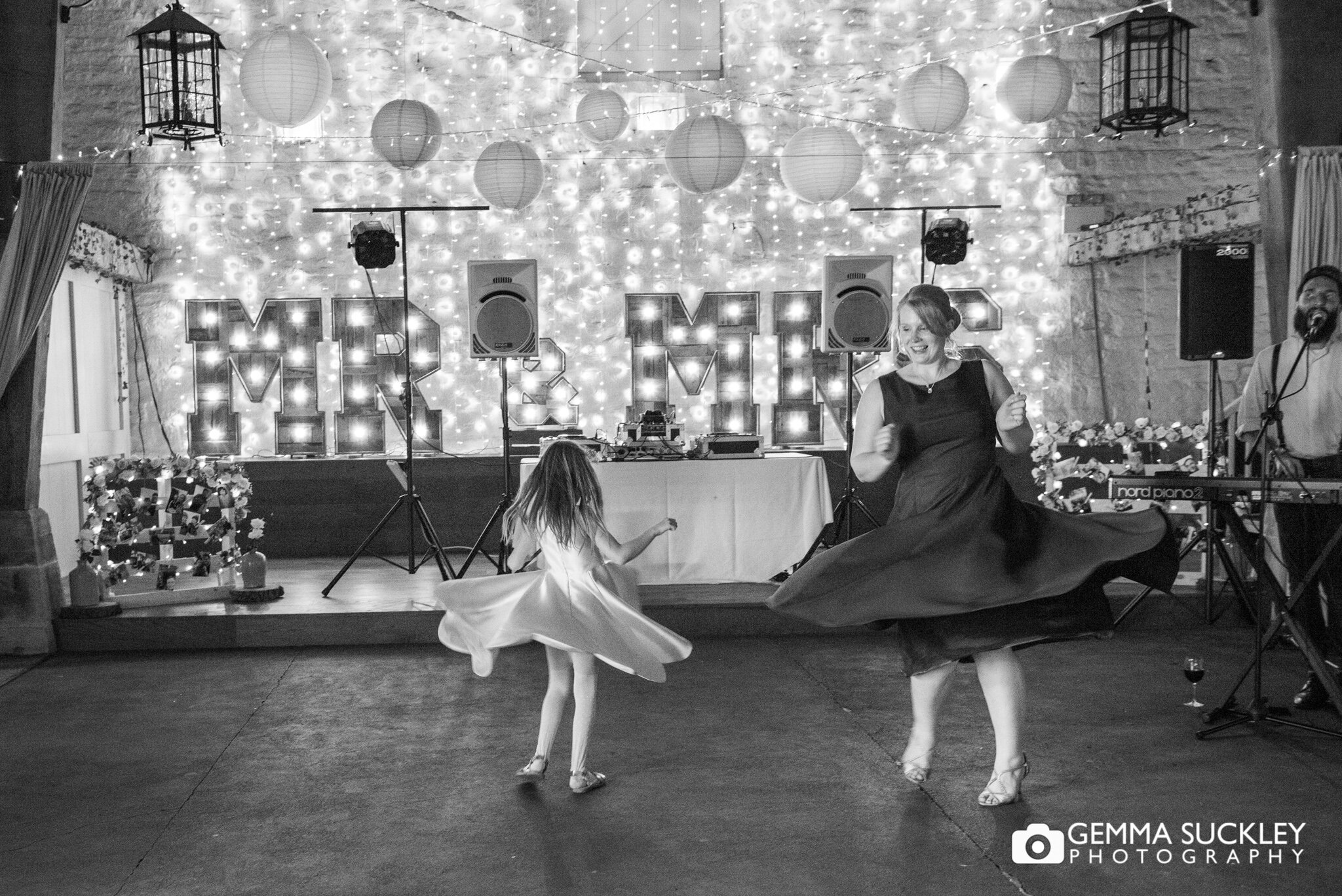 bridesmaid and flower girl spinning on the dance floor as their dances float