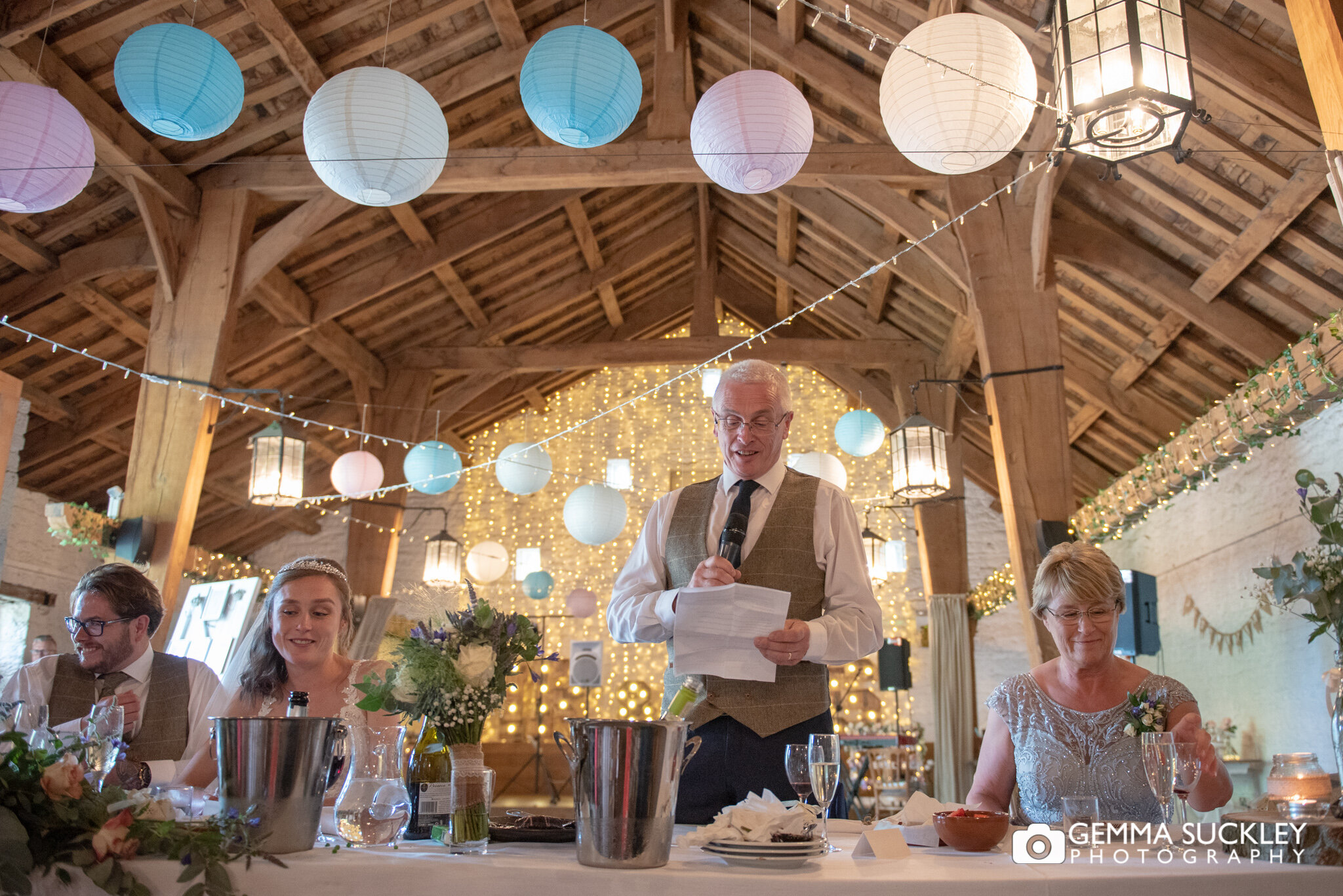 a wide shot of east riddlesden hall barn as the father of the bride makes his speech  