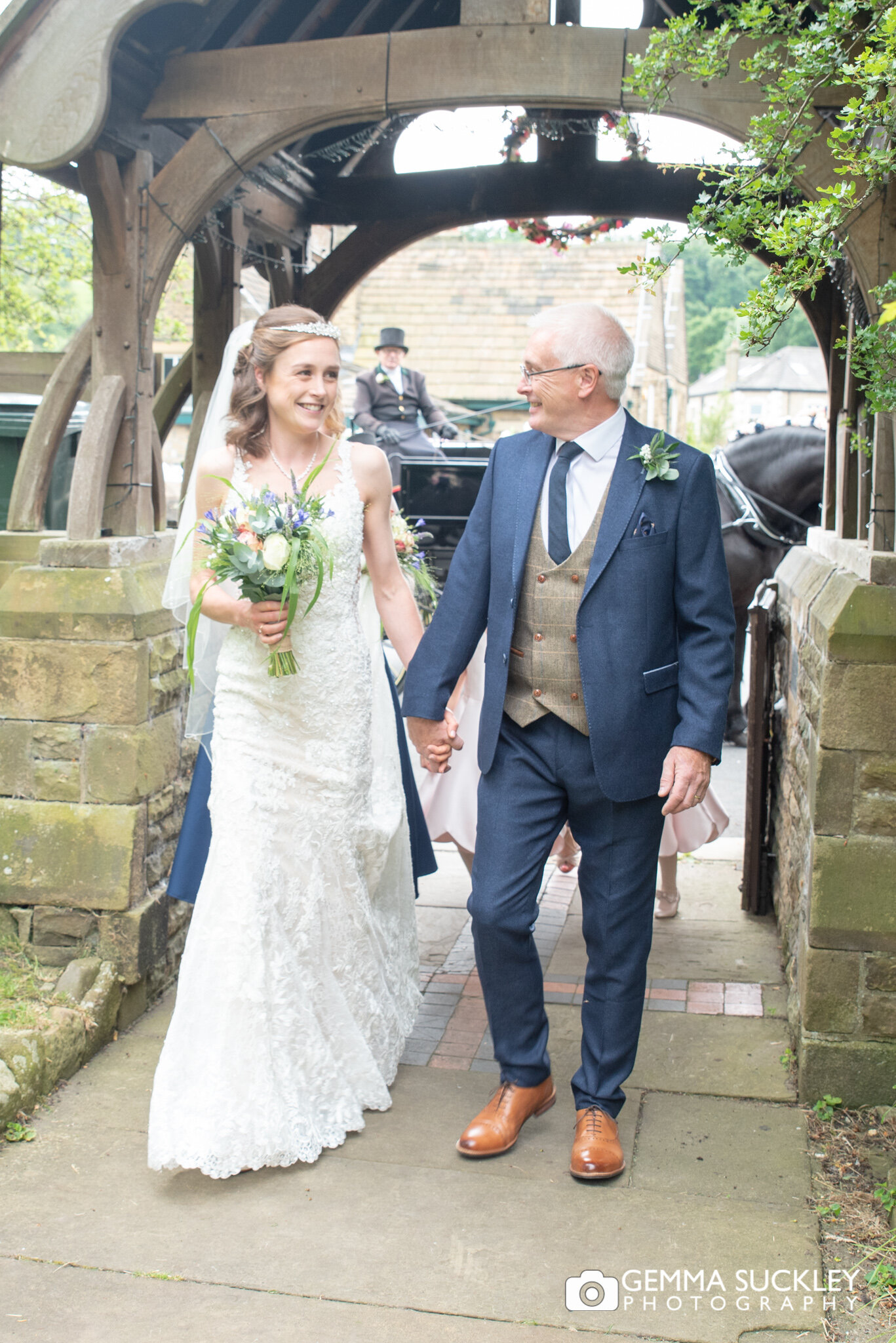 the bride and hwe father walk toward carleton church in north yorkshire