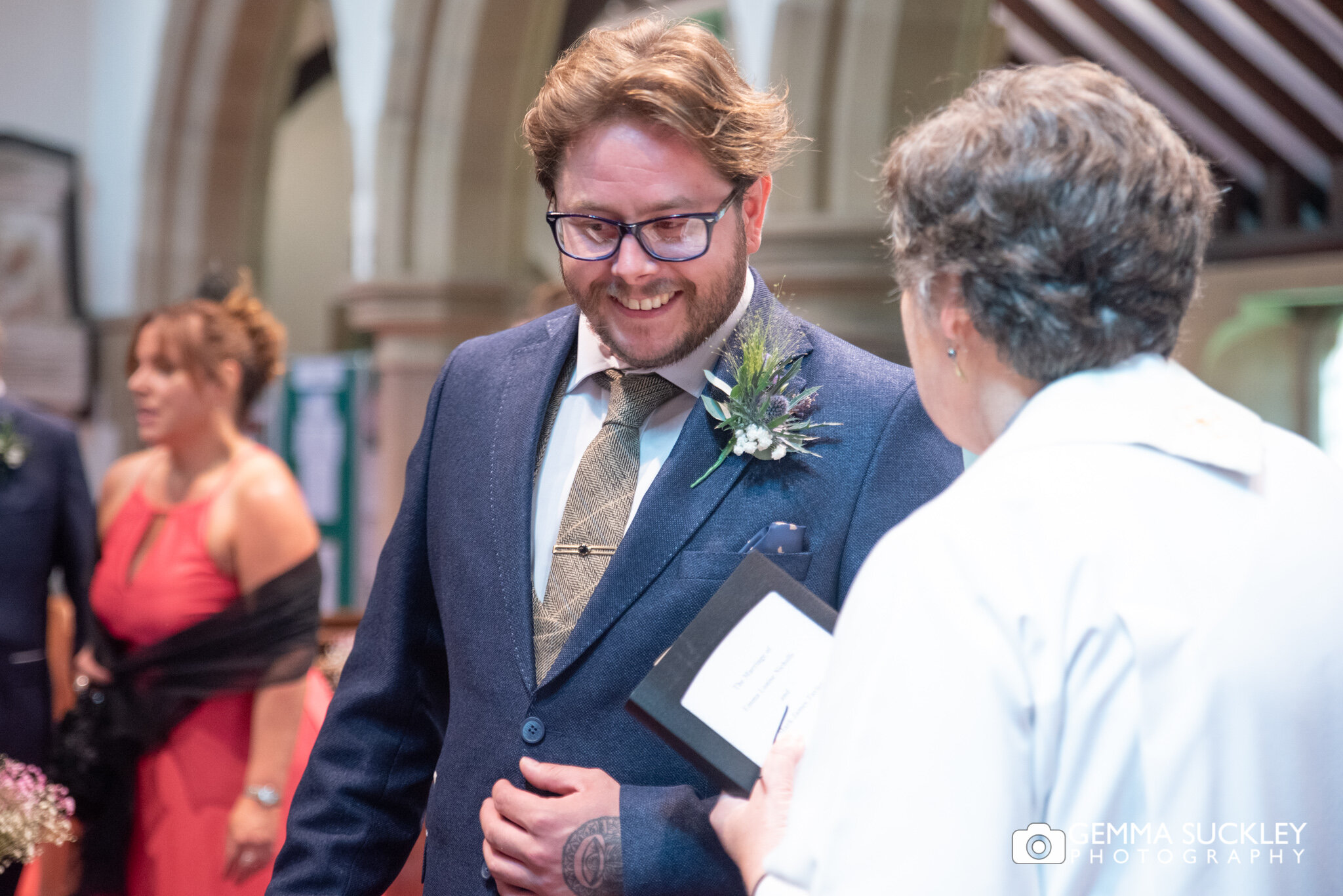 a groom laughing with the vicar at carleton church in north Yorkshire