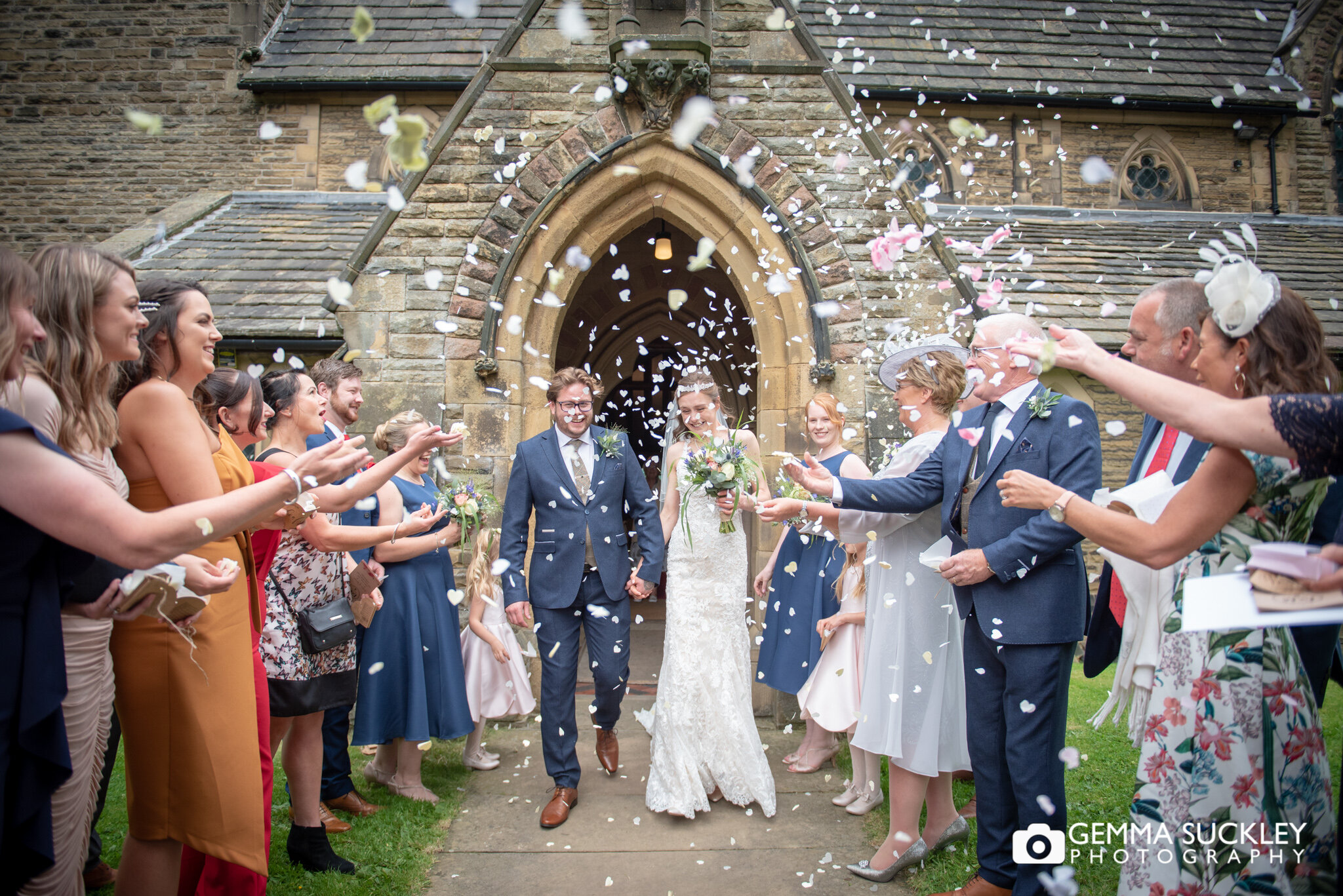 wedding guests throwing confetti at the bride and groom outside Carleton church