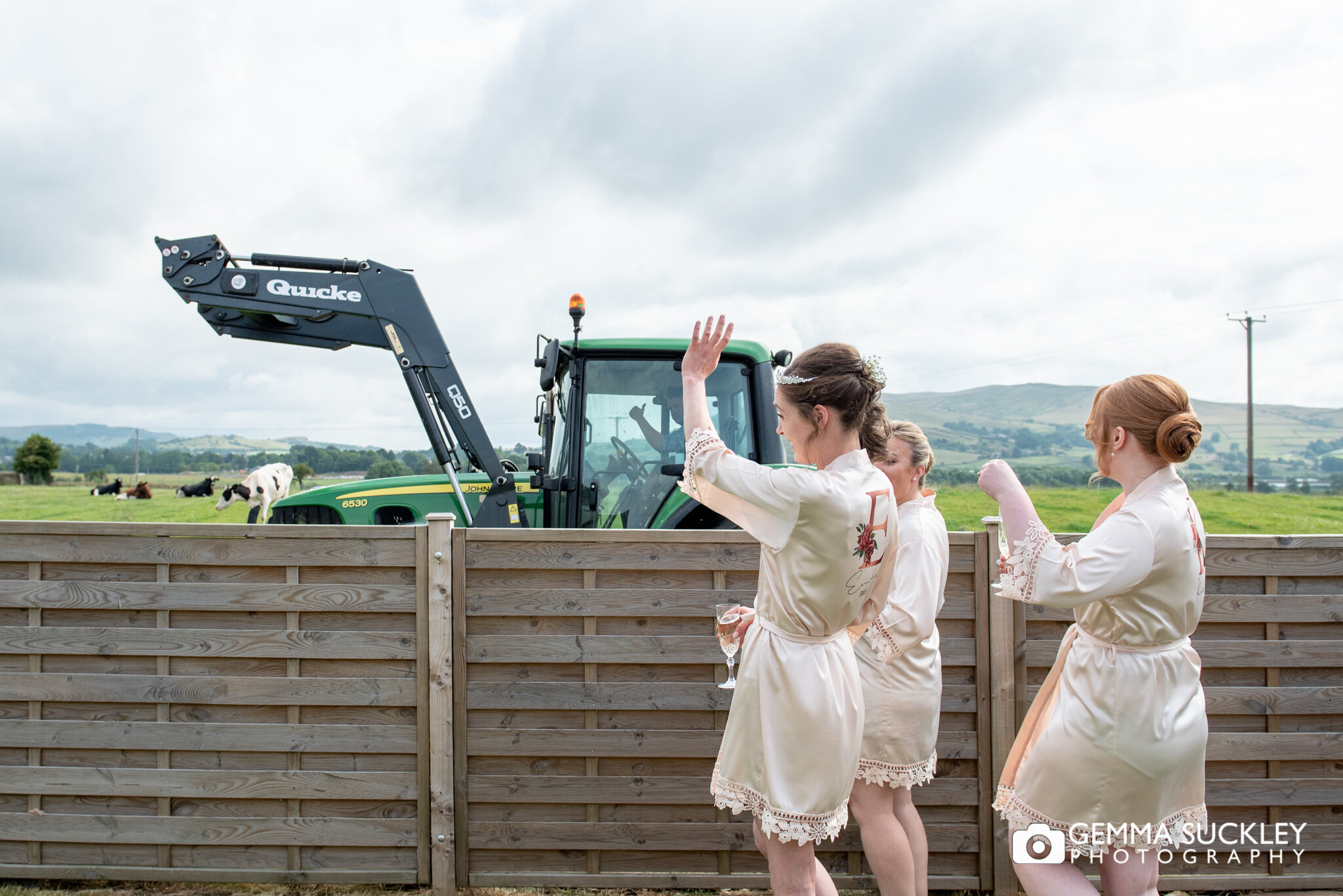 bridesmaids waving at a passing farmer in his tractor 