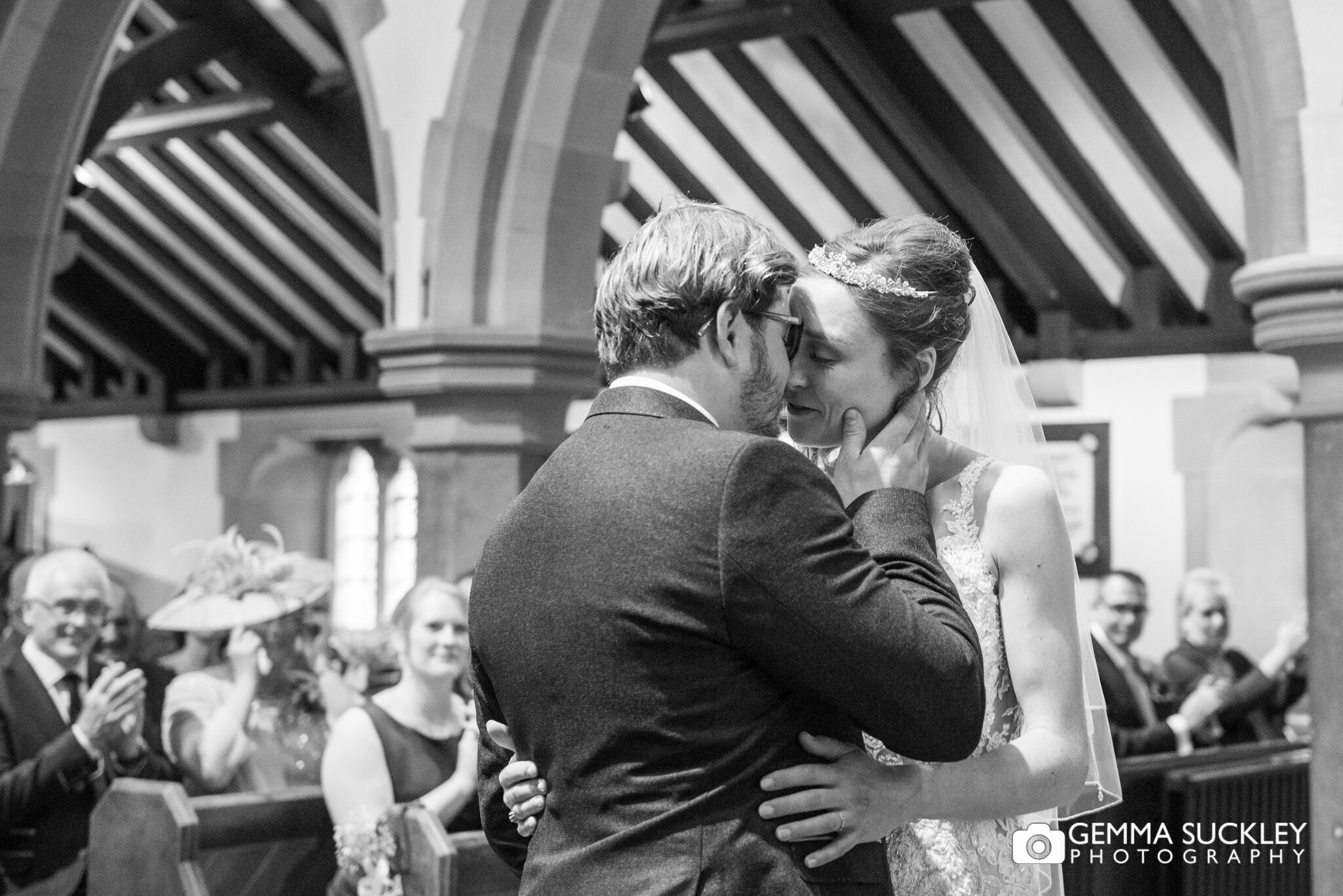 black and white photo of the bride and groom kissing after their vows