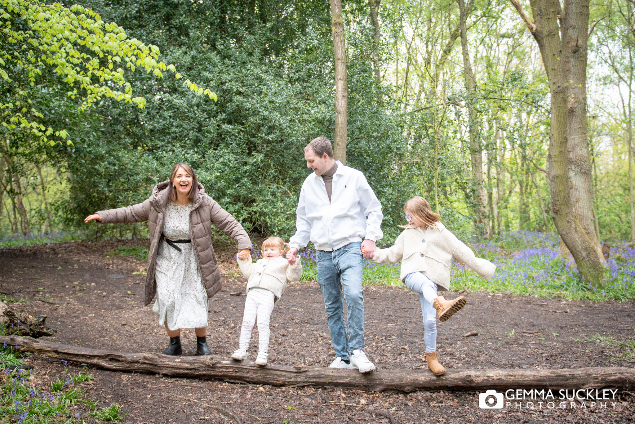 fun photo of a family balancing on a log in hirst wood