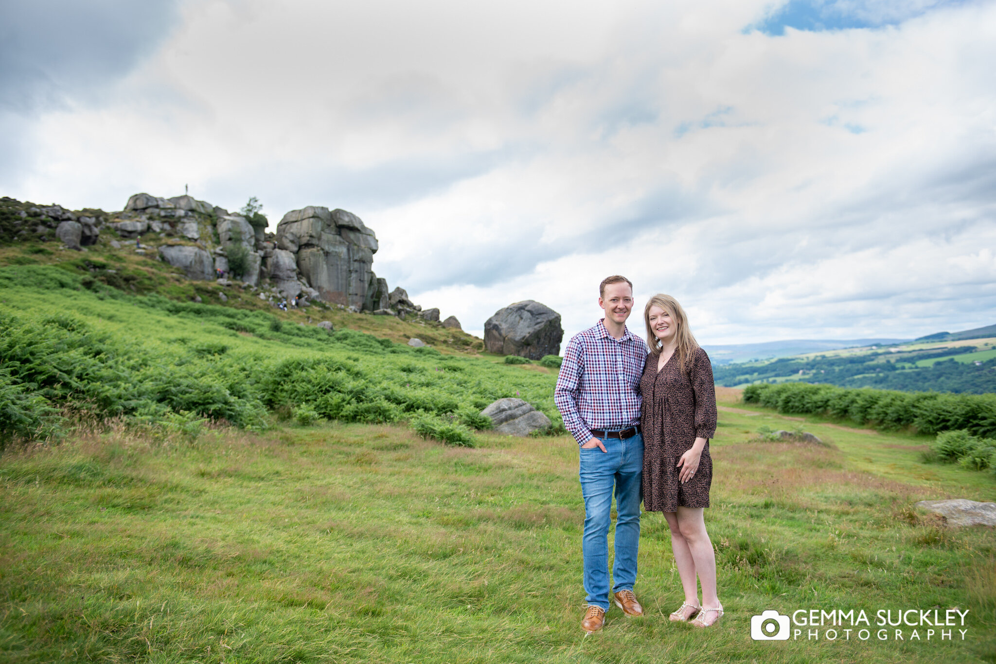 engagement shoot of a smiling couple by the cow and calf
