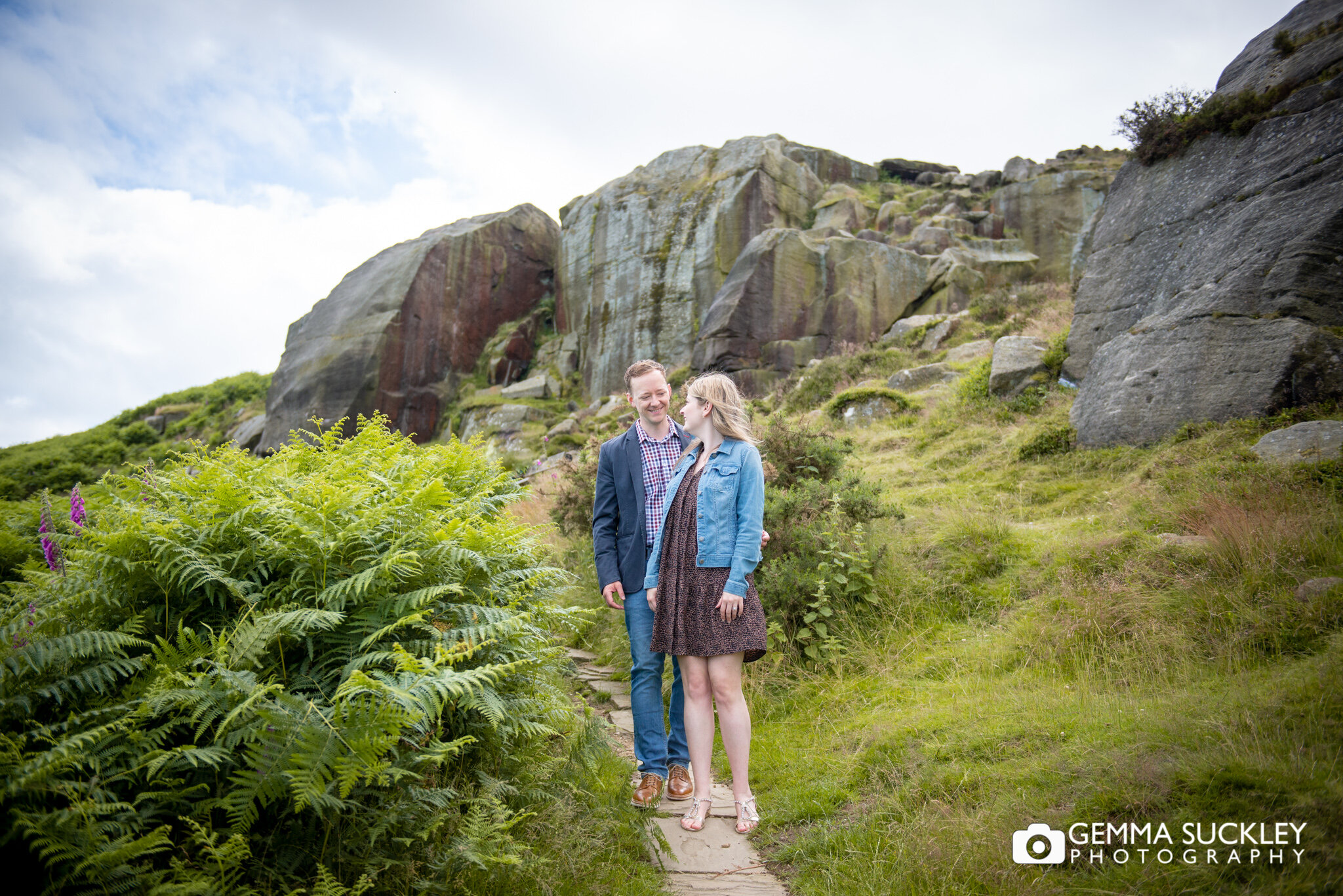 an engaged couple walking past the cow and calf on ilklely moor
