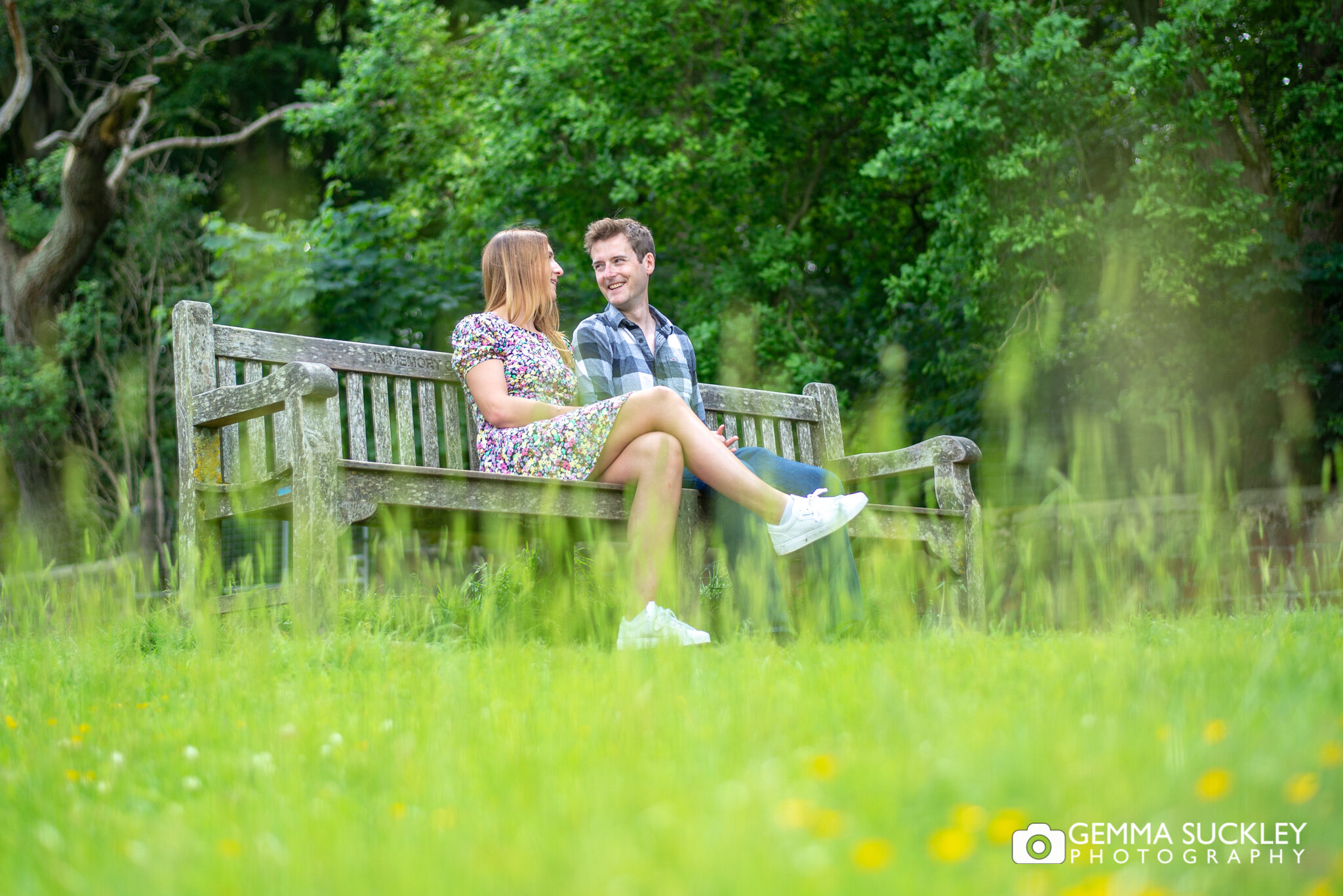 engaged couple sitting on a beach in harewood estate