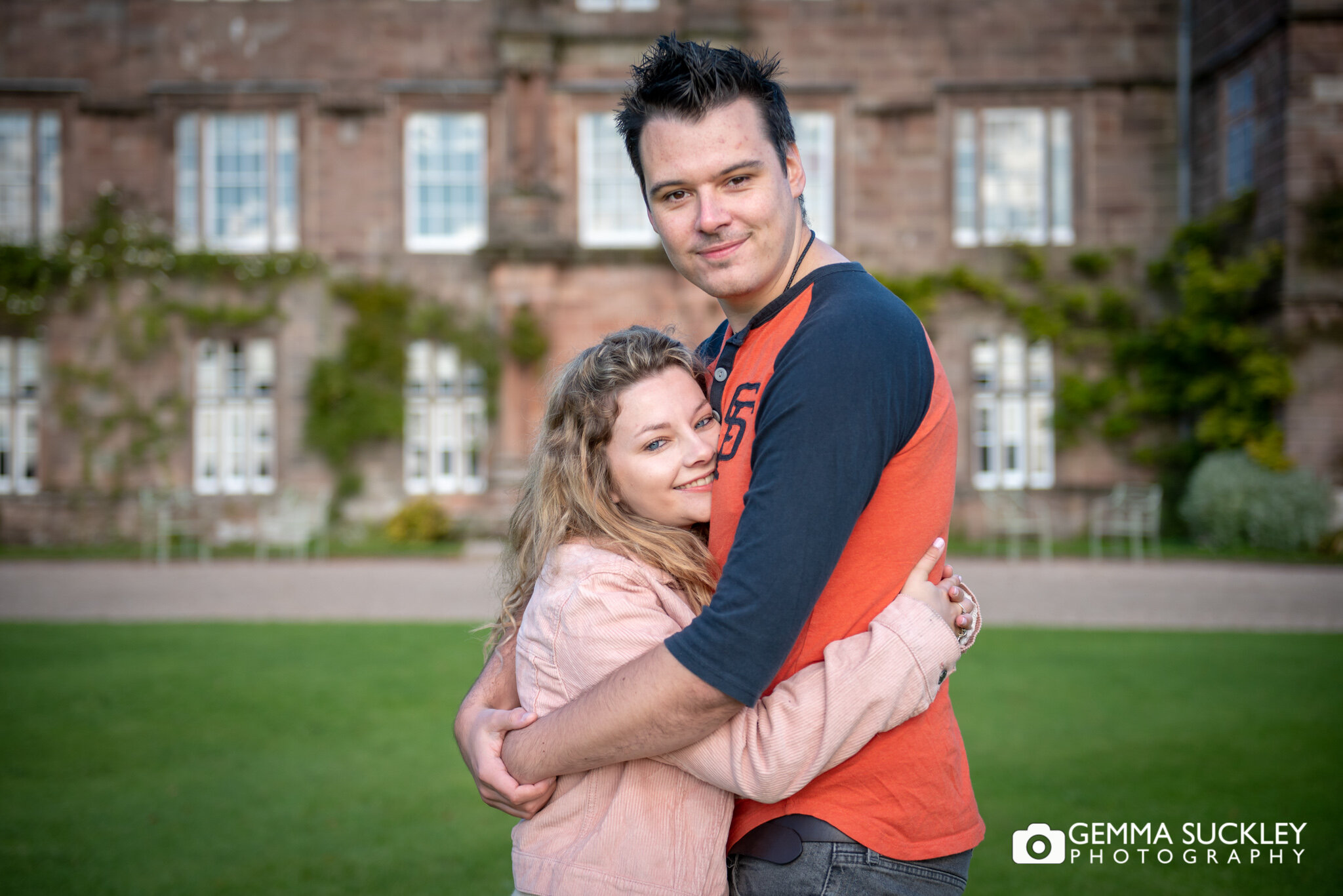 a couple hugging in front of Browsholme hall in clitheroe