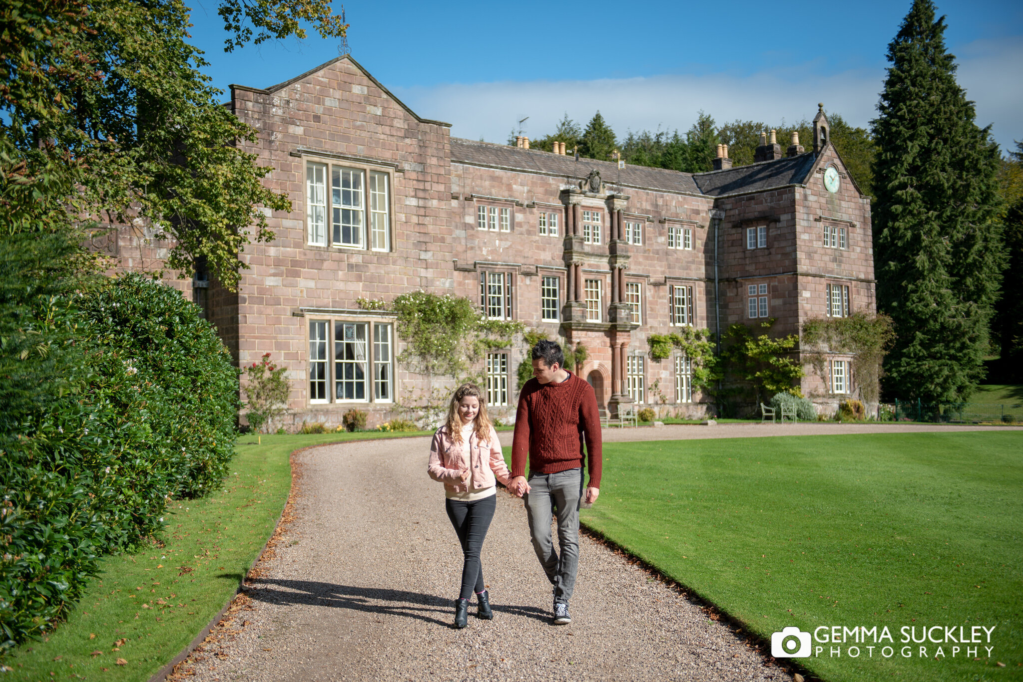 pre wedding photo of a couple walking in front of browsholme hall