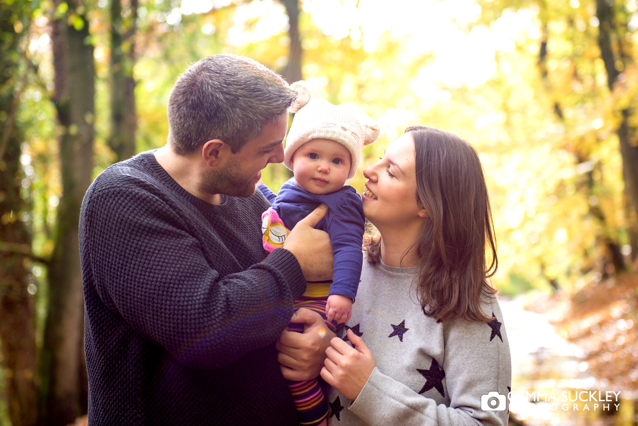 a couple and their baby in skipton woods during autumn 