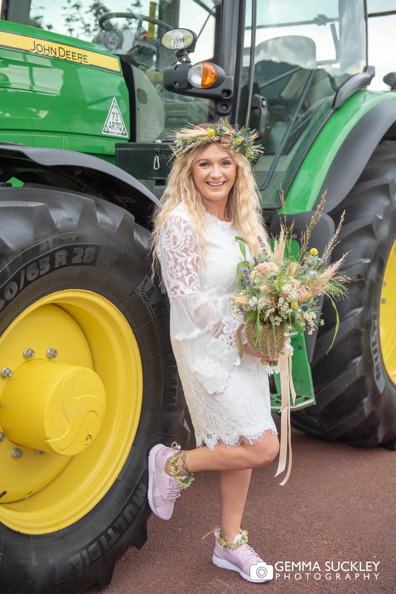 the bride laughing at the camera infront of the tractor