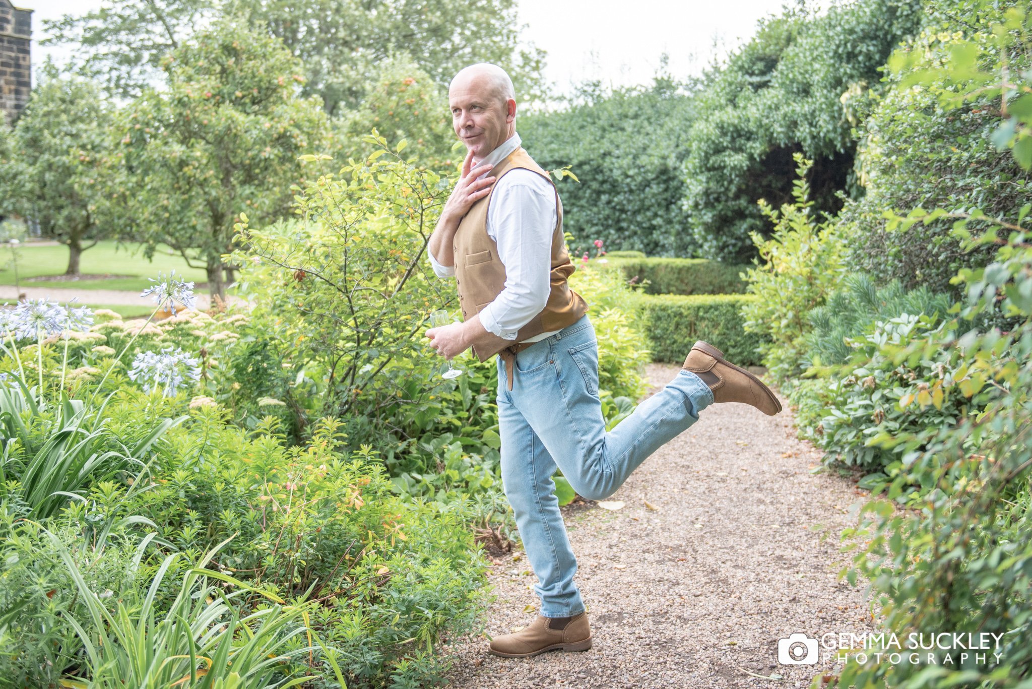fun photo of the groom in the garden at east riddlesden hall