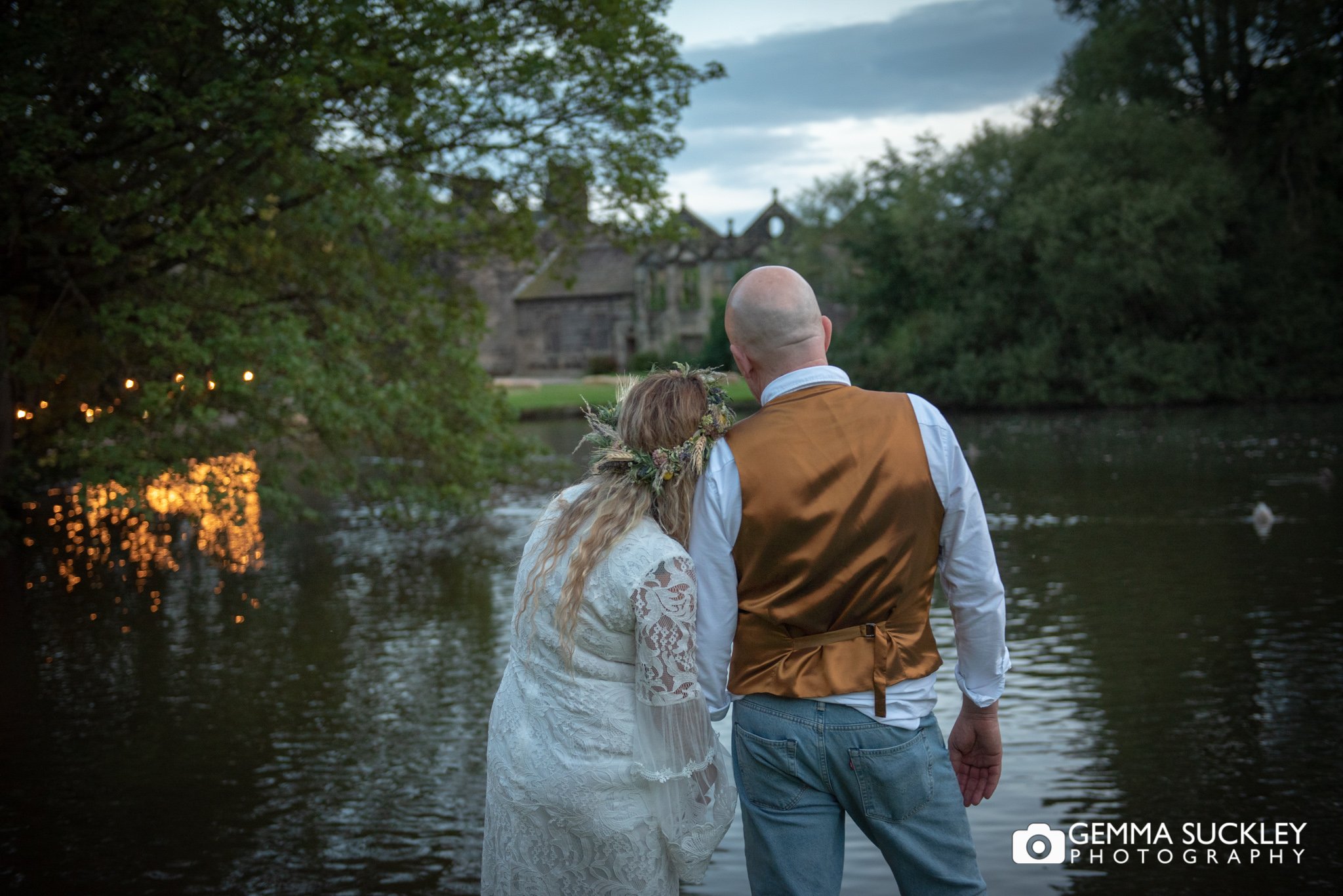 night photography of the bride and groom overlooking the pond at east riddlesden hall