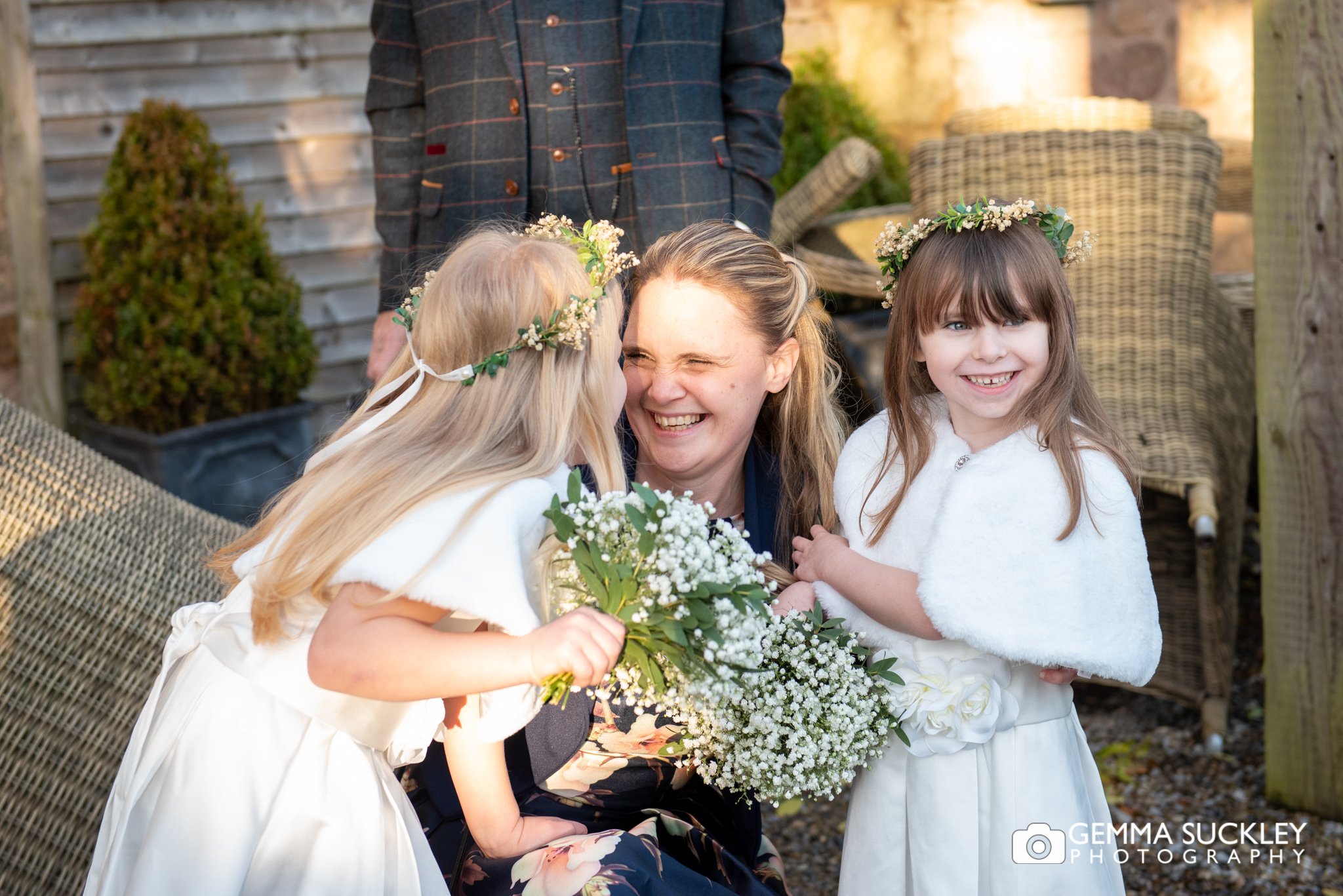 candid photo of a guest laughing with the flower girls outside the shireburn arms