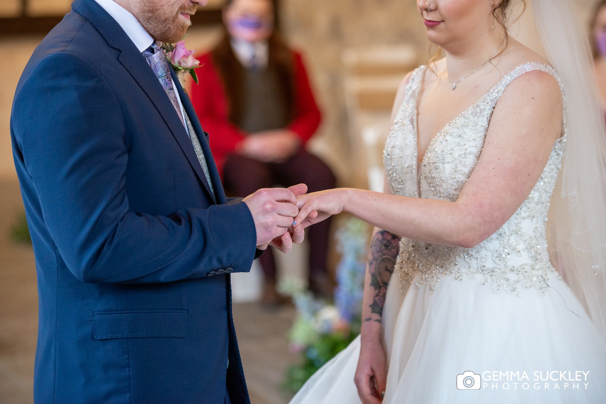 the groom putting the ring on his brides finger