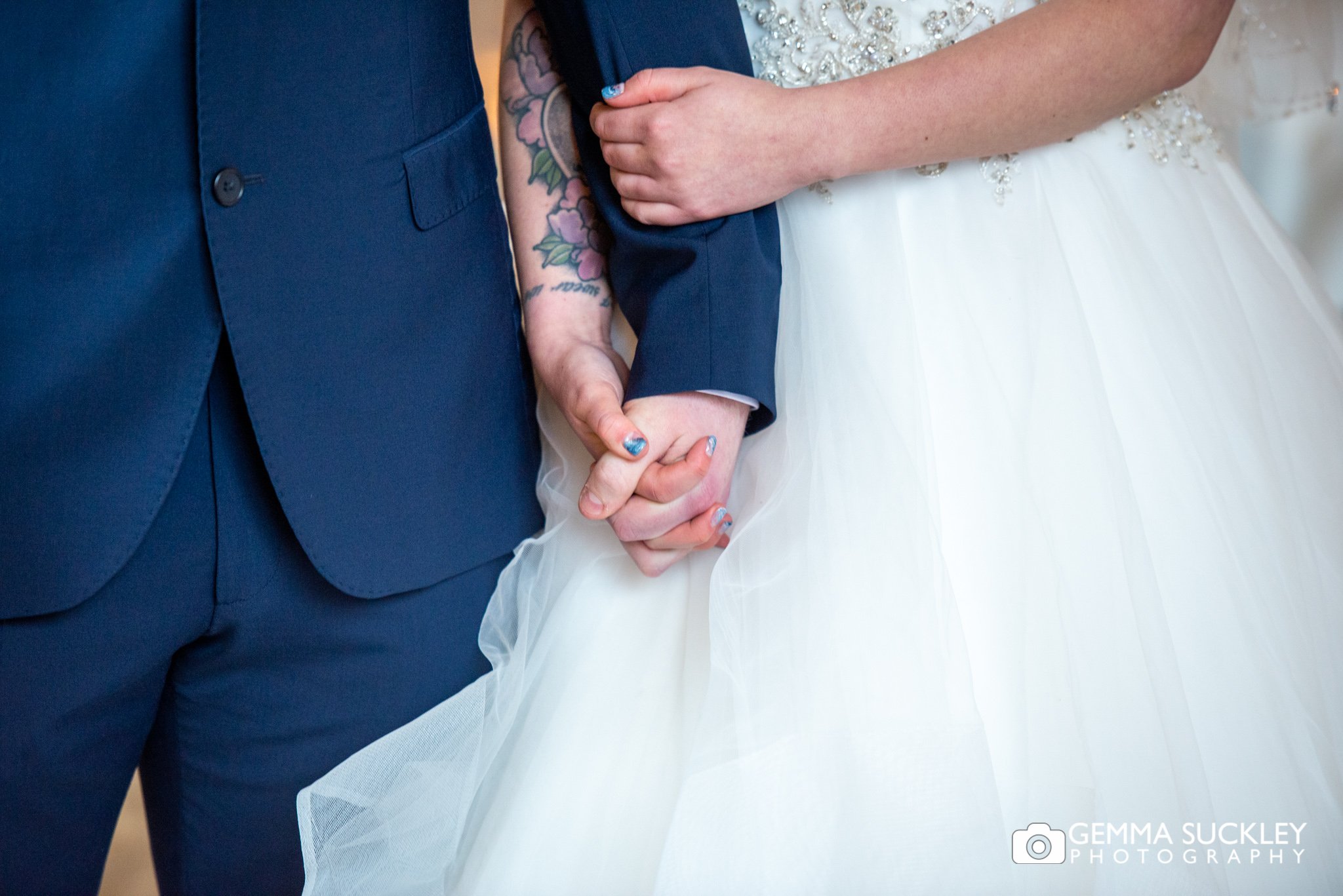 close up photo of the bride and grooms hands at the priests house