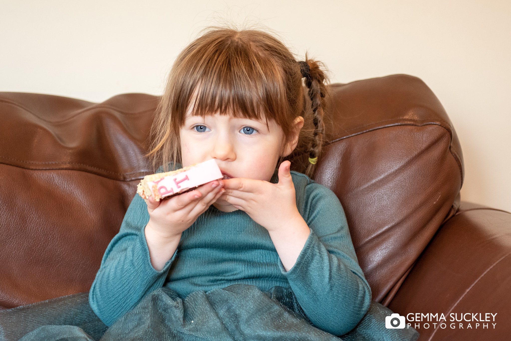 a little girl eating birthday cake