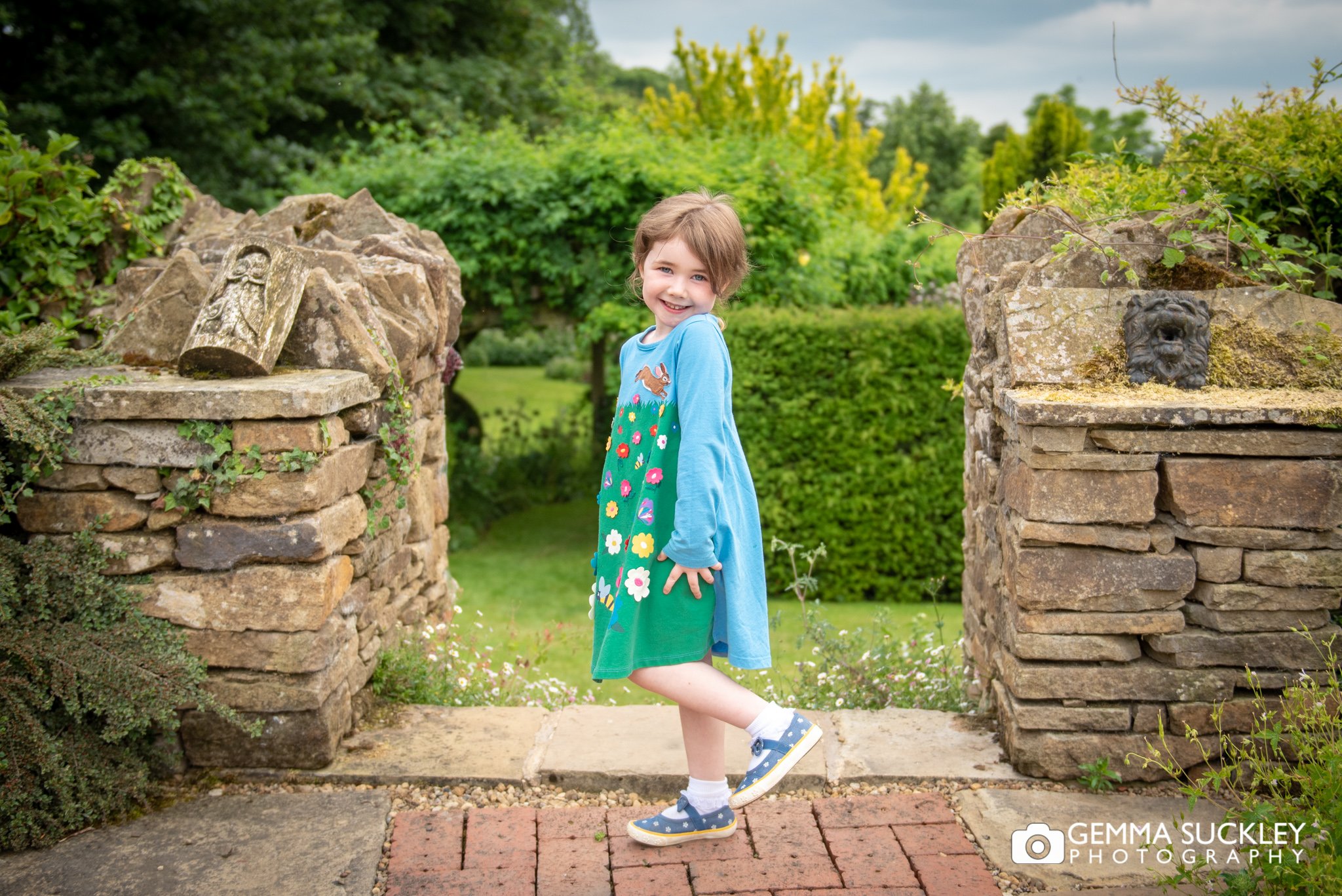 a little girl in her summer dress smiling of a family portrait 