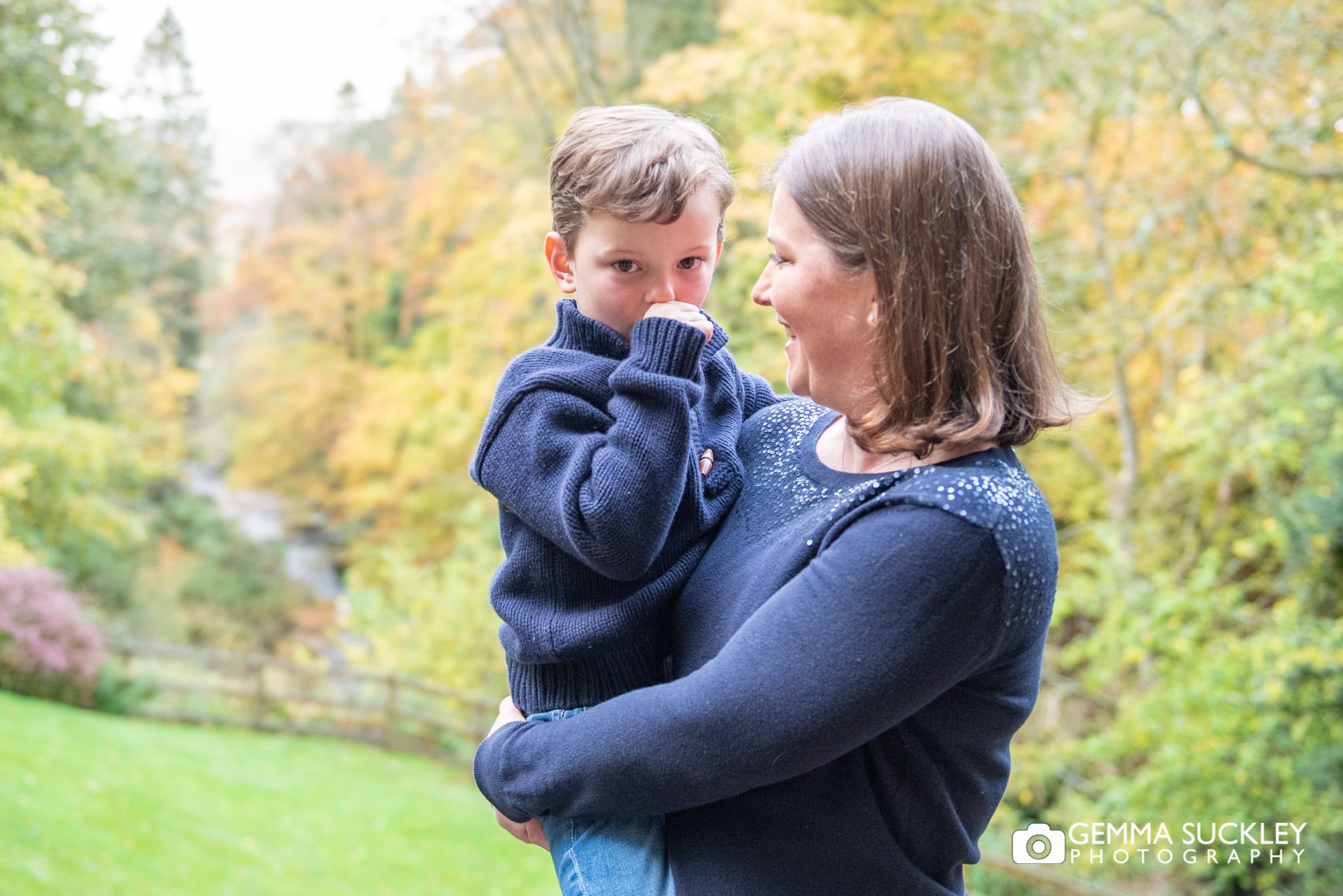 a little boy in this mums arms for a family photo 