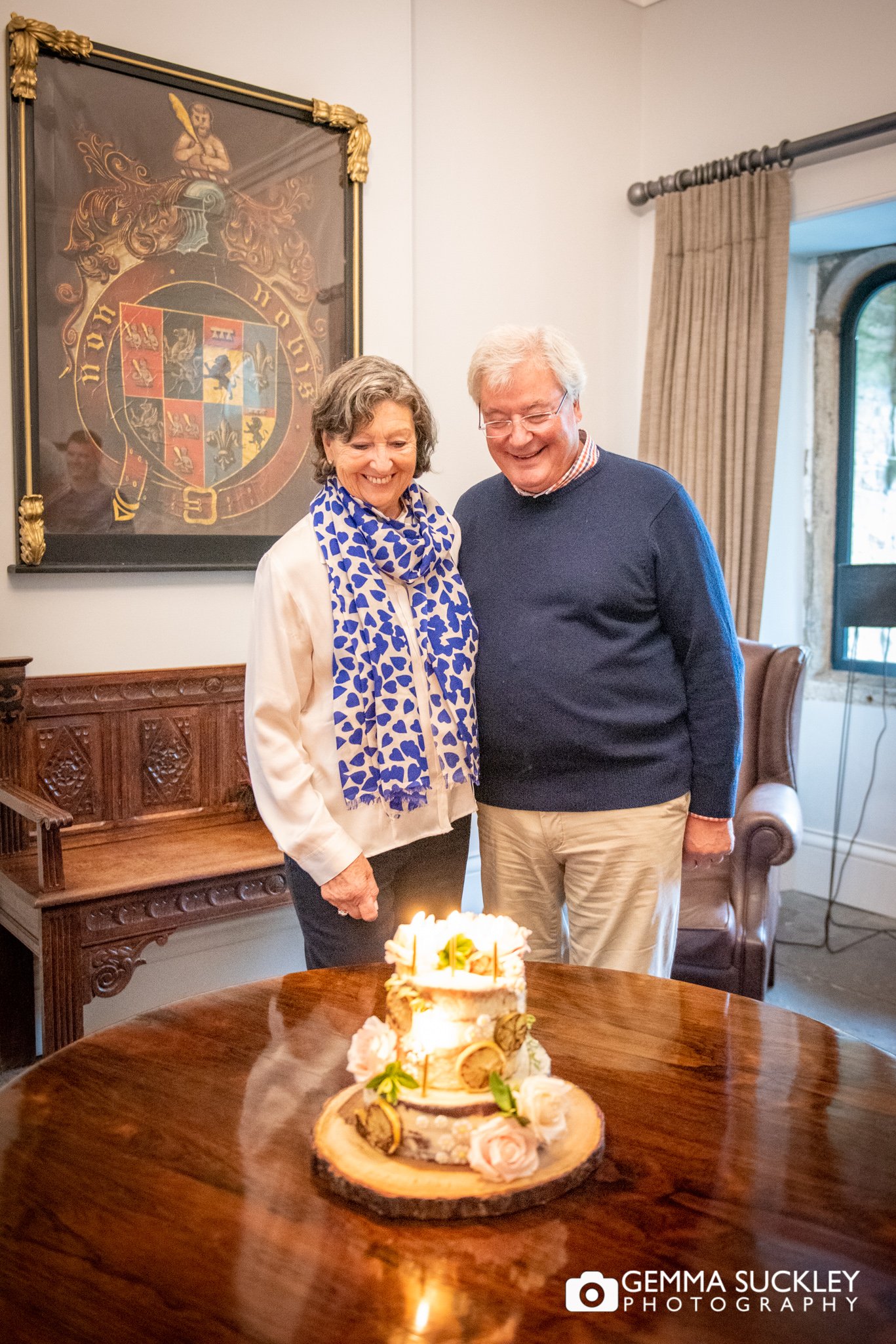 a couple cutting their golden anniversary cake