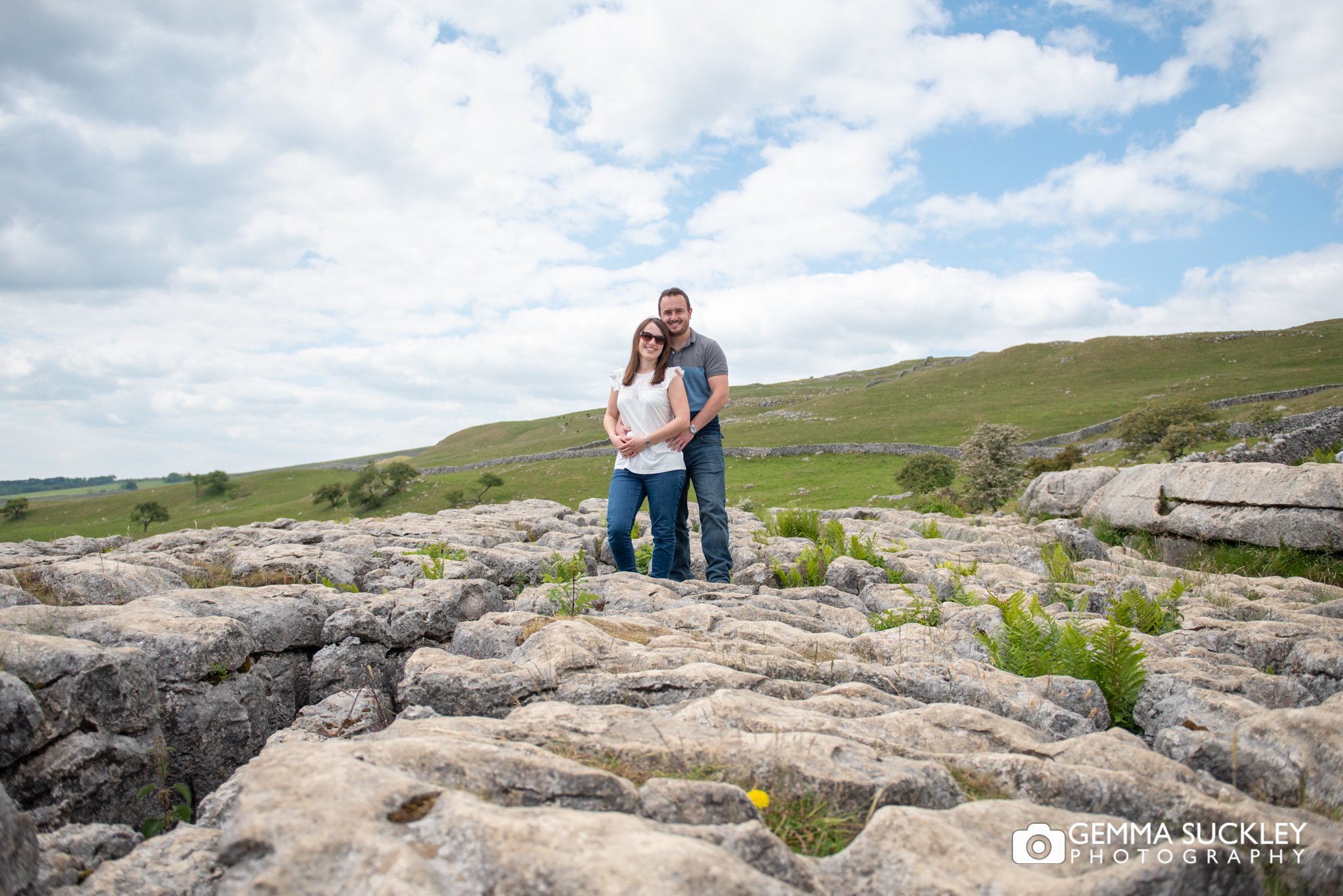 engagement photo of a couple on top of malham cove