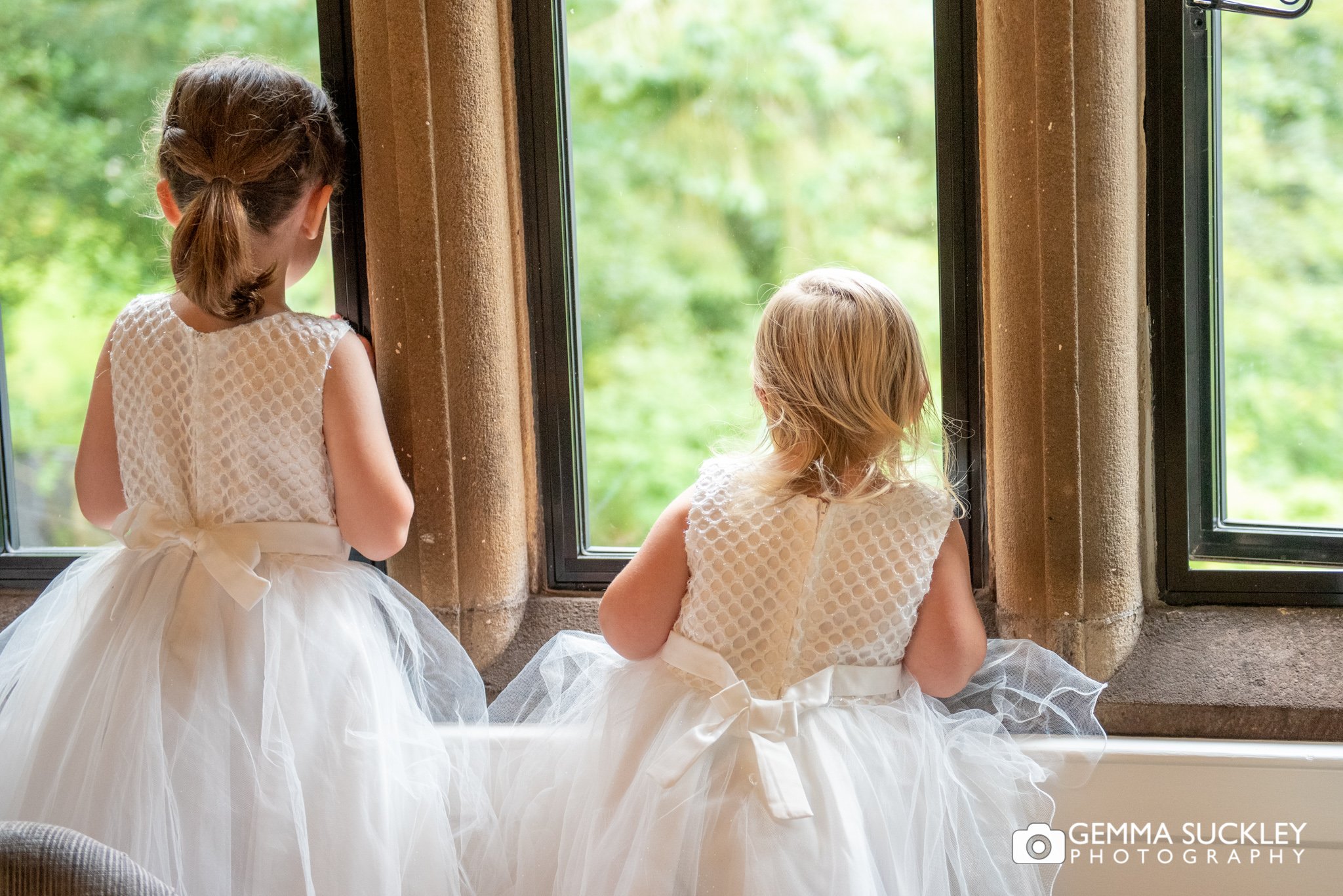 two flower girls looking out the window at oughtershaw hall 