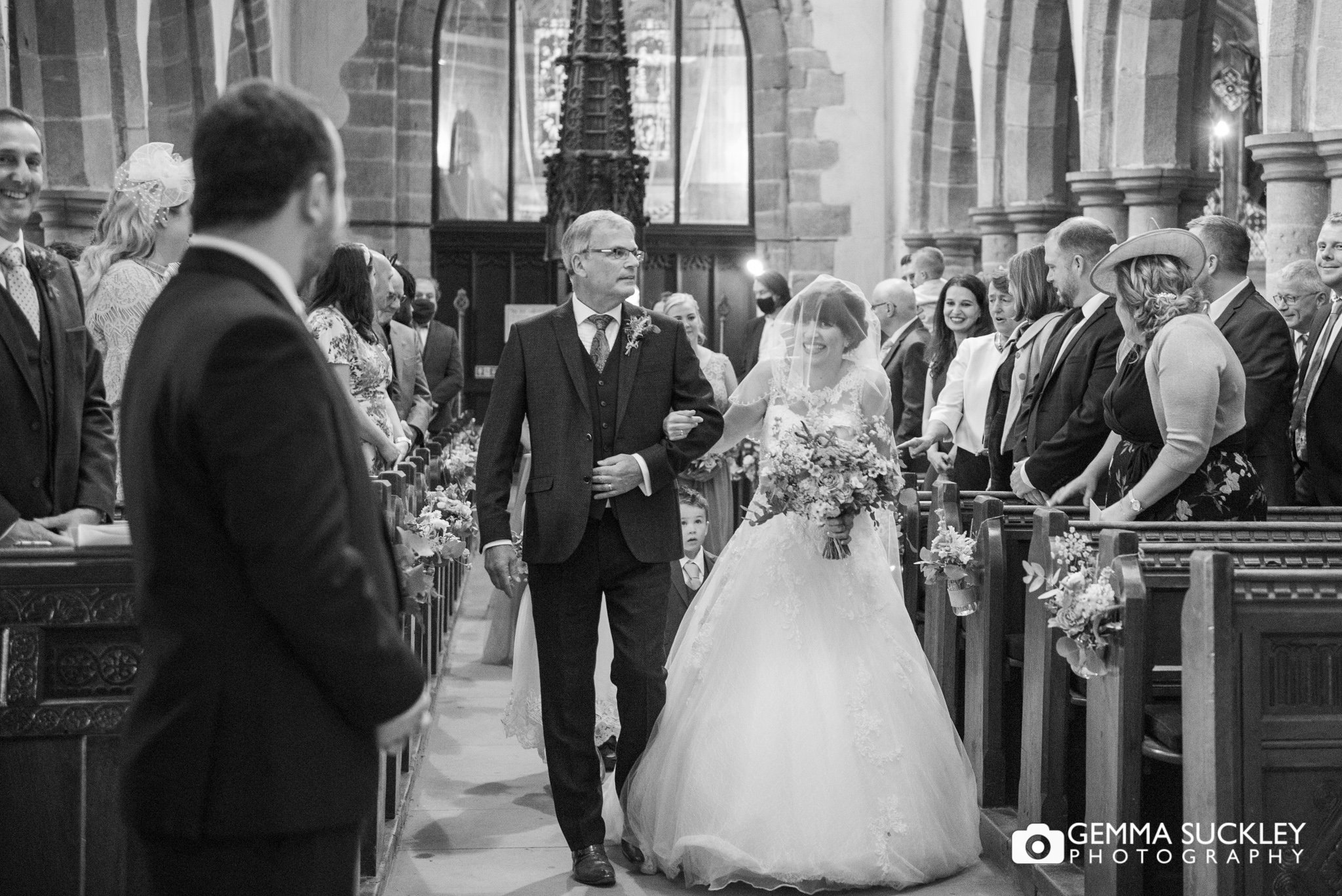 black and white wedding photography  of bride walking  down the aisle at kickwick chuch