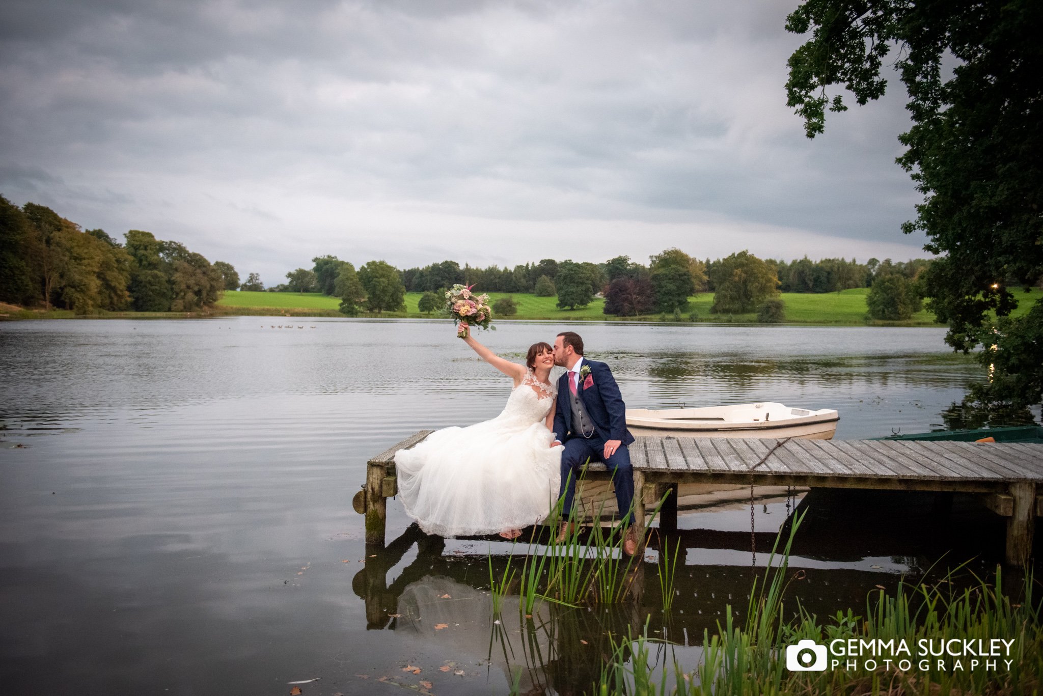 bride and groom sitting on the jetting at coniston hotel lake