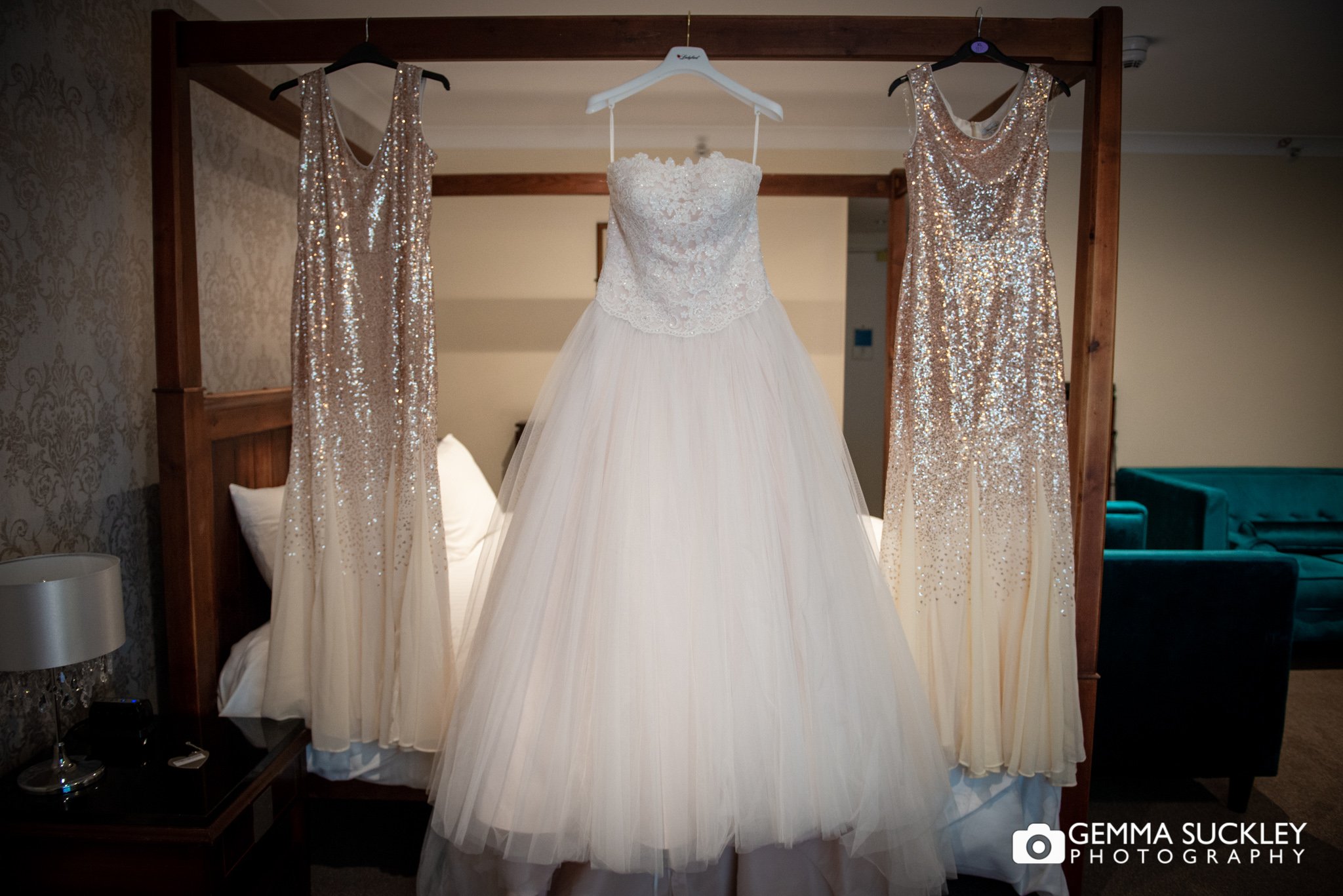 wedding dress and bridesmaid dressing hung up at hollins hall