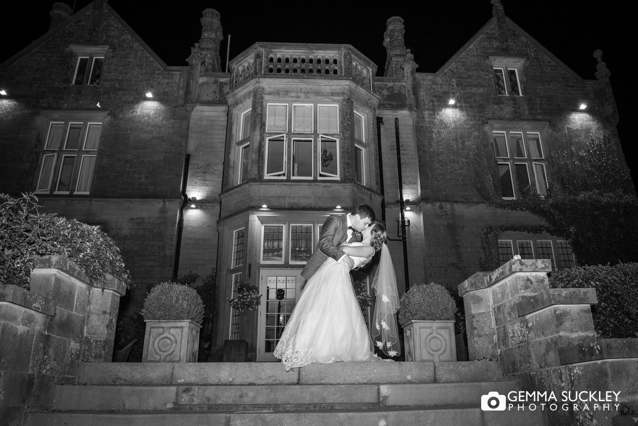 night photography of the bride in the grooms arms outside the falcon manor