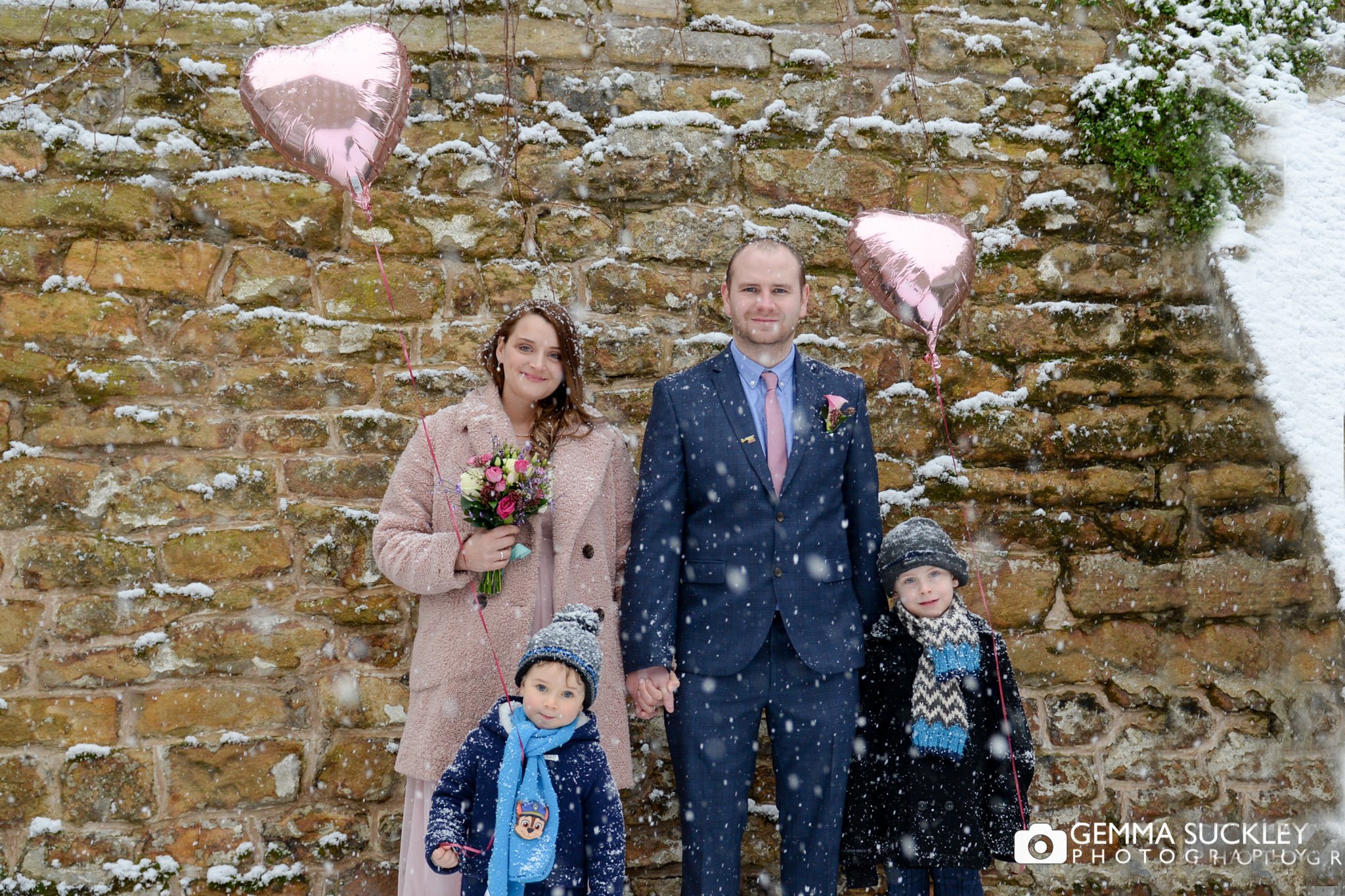 bride and groom with their sons in the snow