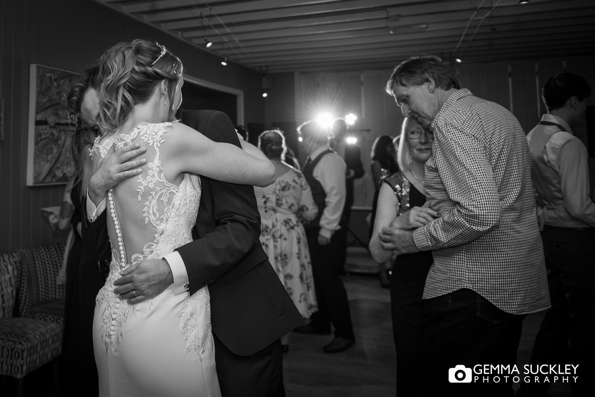 bride and groom dancing as their parents dancing alongside them