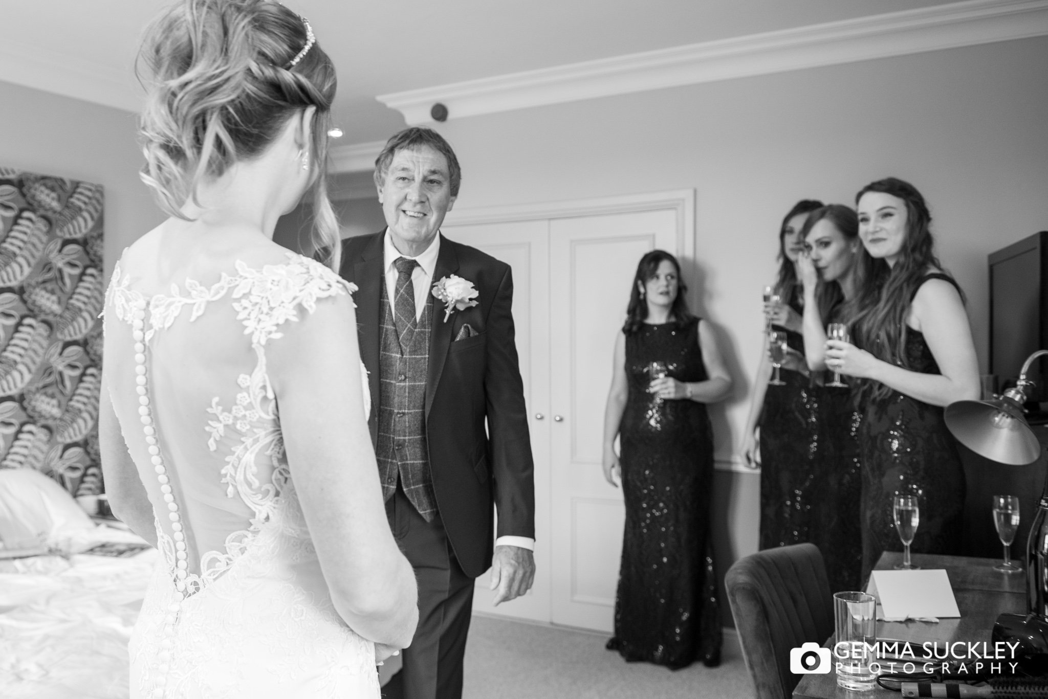 the father of the bride looking at his daughter  in her dress