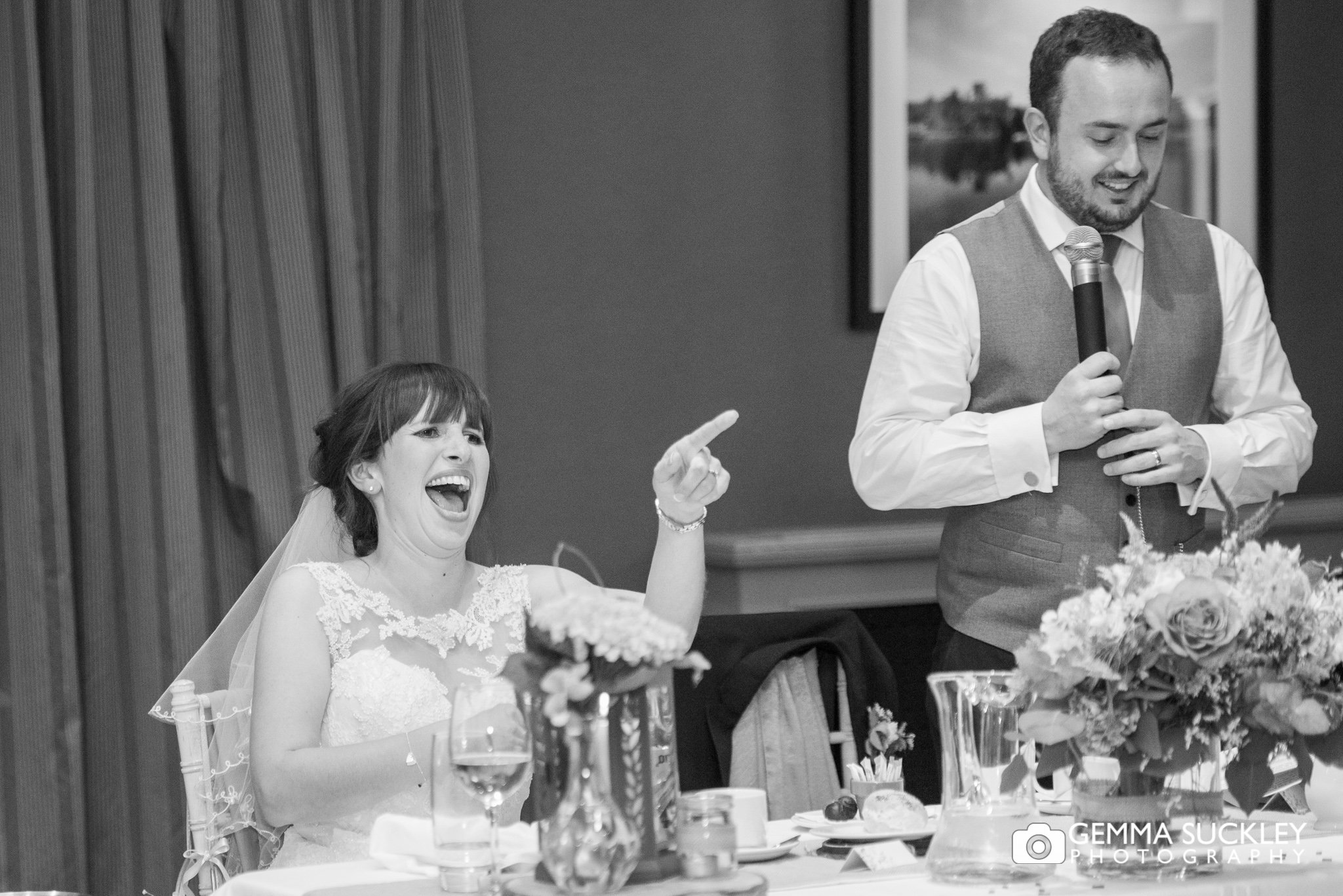 bride laughing and pointing as the groom makes his speech at the coniston hotel