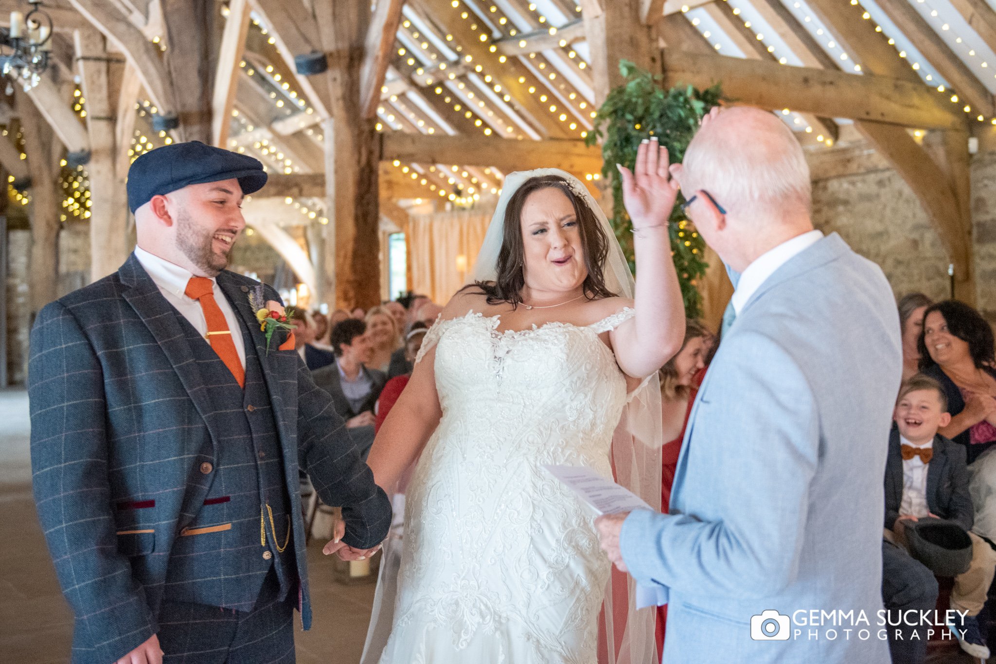 bride high fives the priest during her wedding ceremony