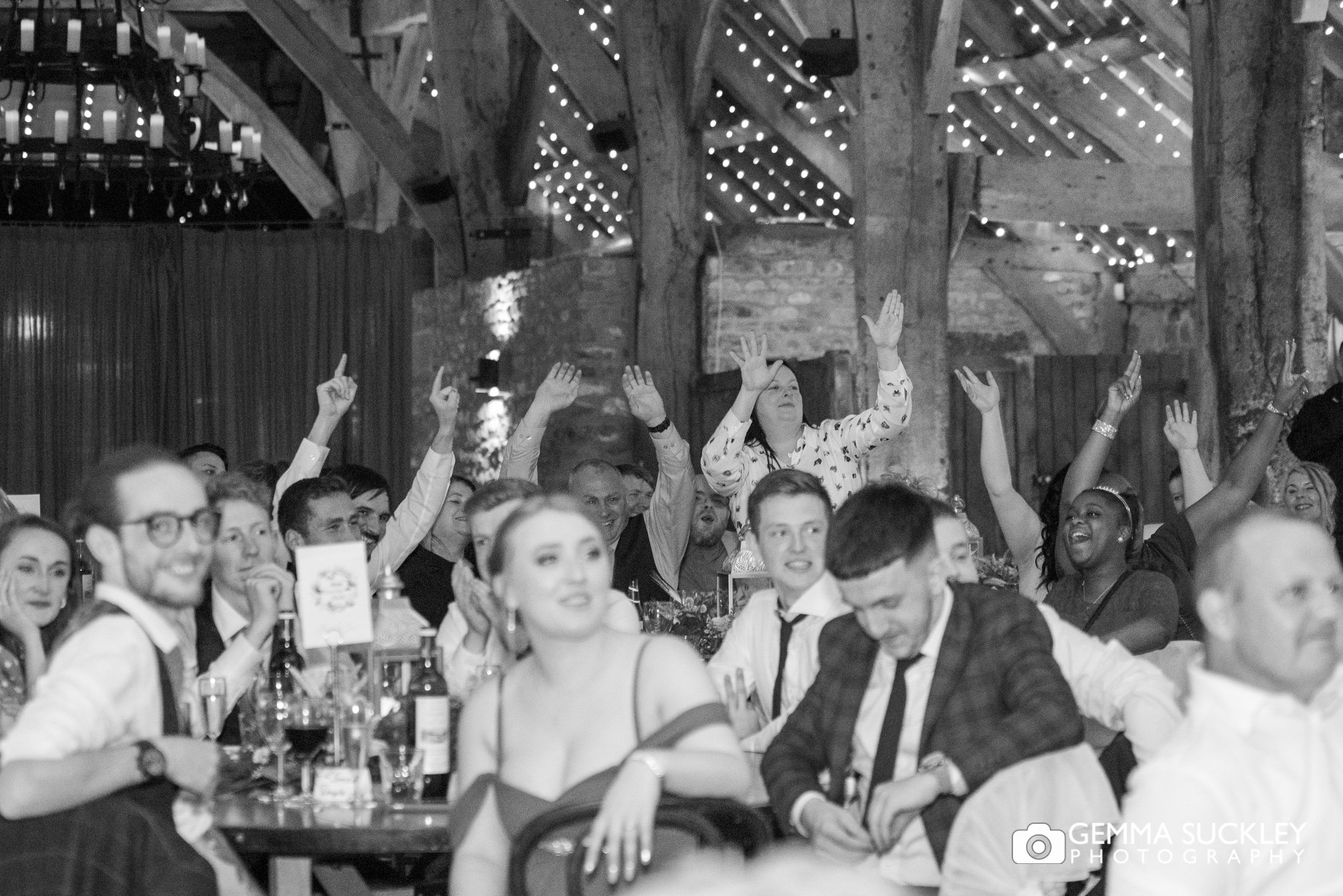 wedding guests cheering during wedding speeches at the tithe barn in bolton abbey