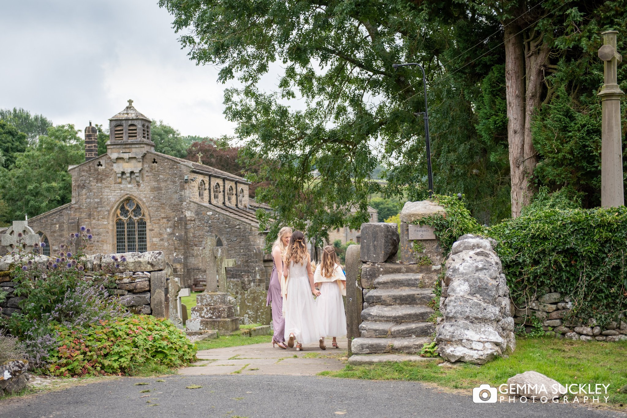 establishing photo of linton church and the flower girls walking into the church yard