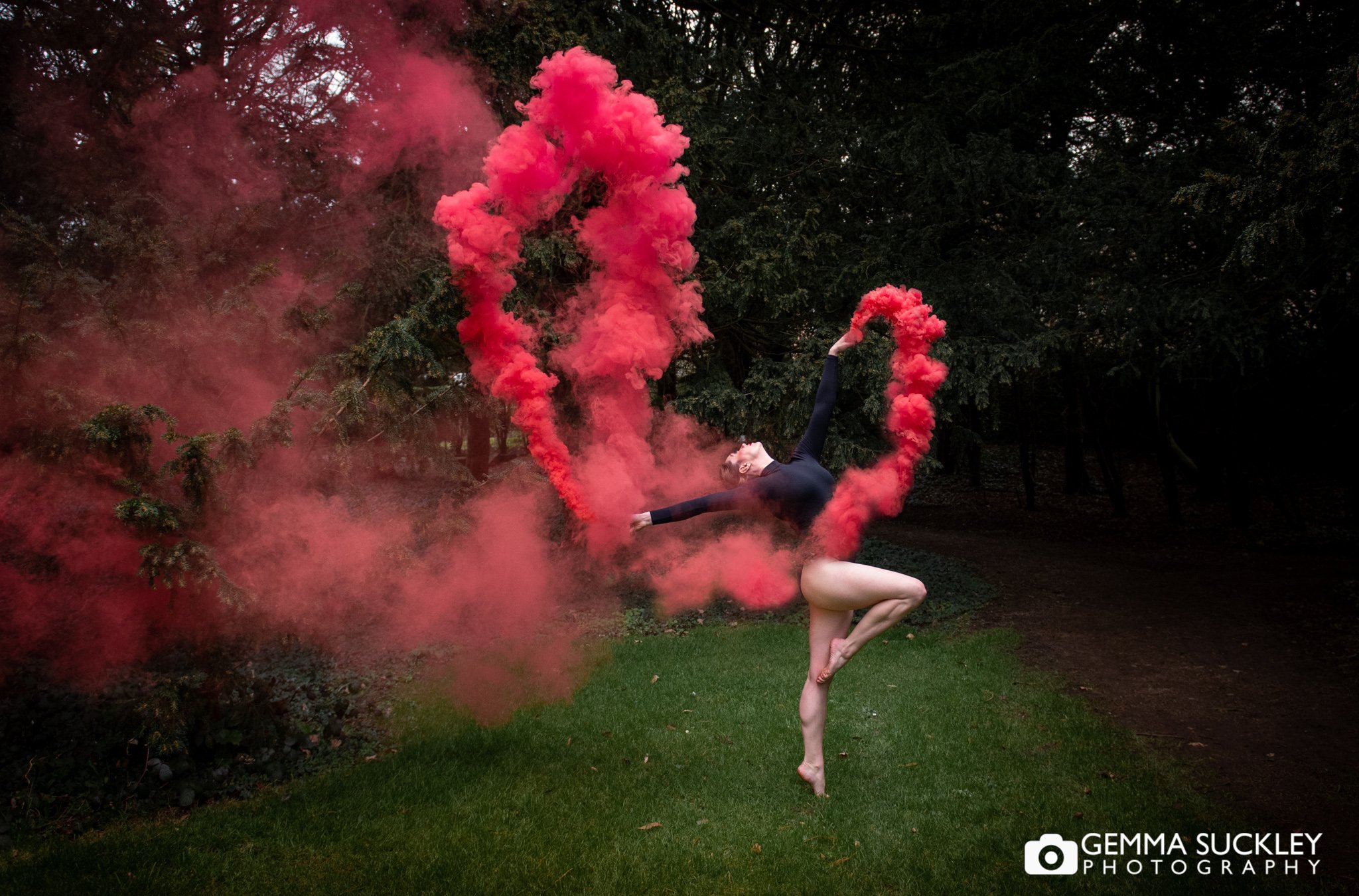 a ballet dancer is movement with a red smoke bomb