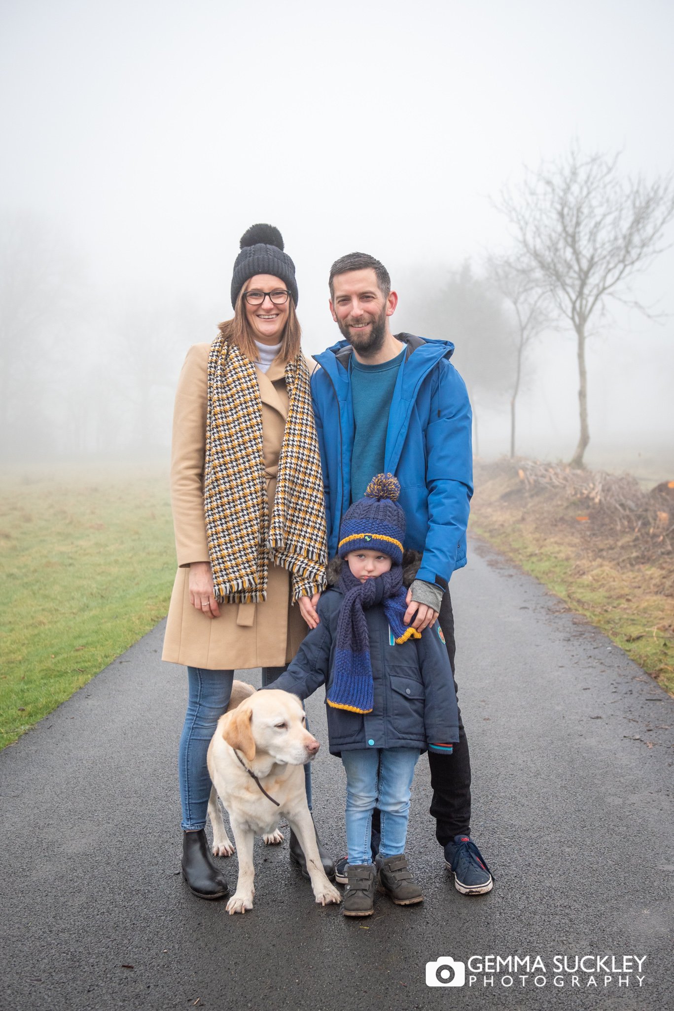 winter family photo of a little boy and his dog and parents