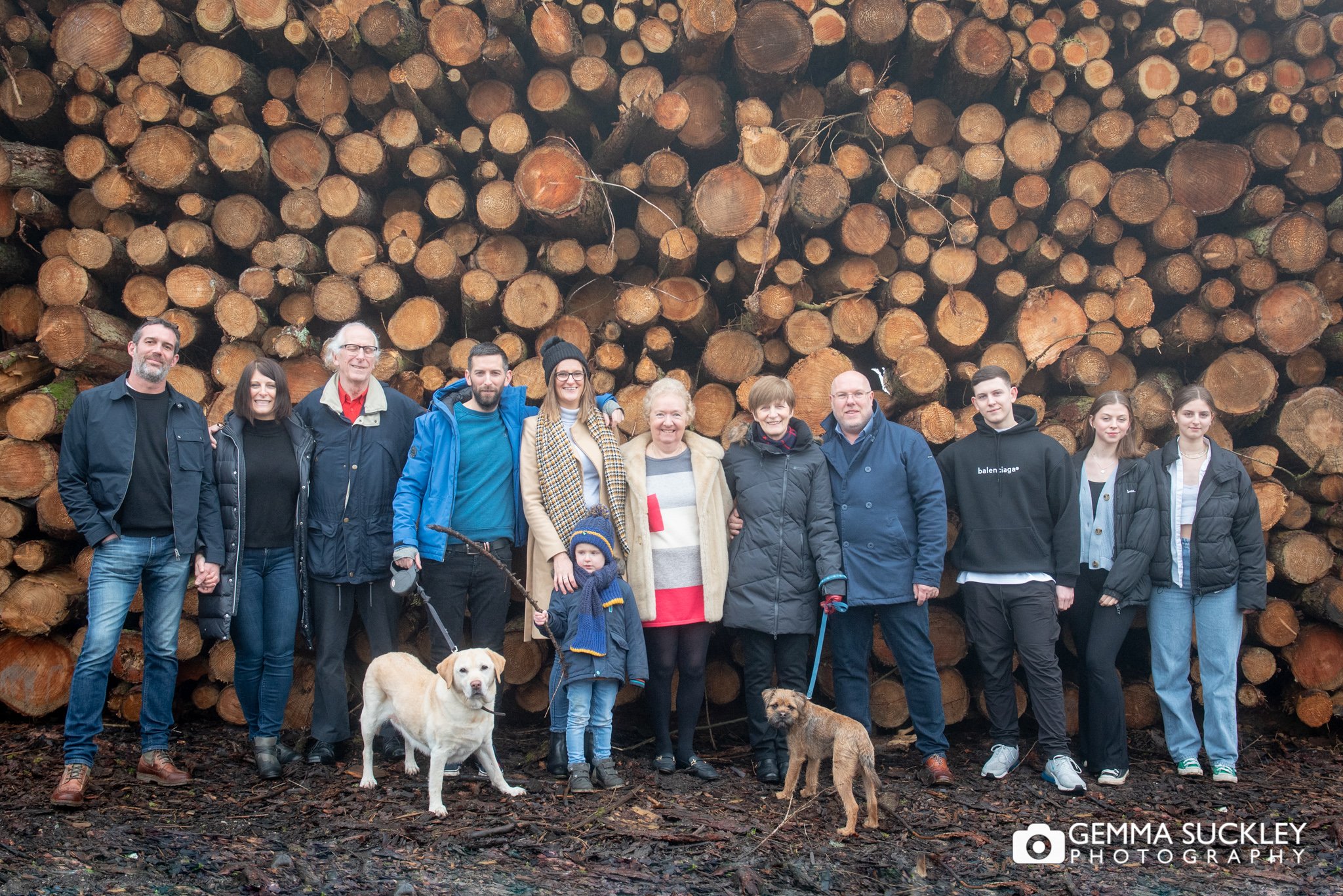 large family photo in north yorkshire in front of a wood pile 