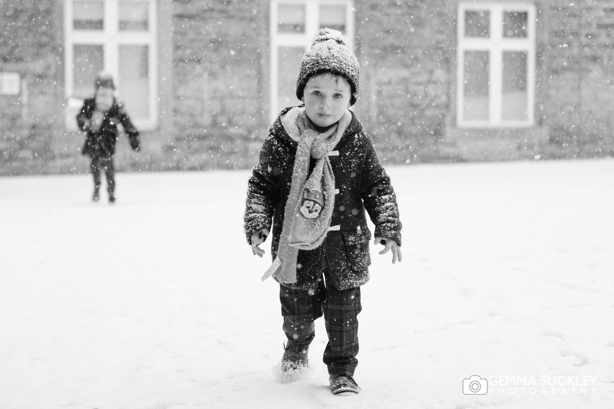 pageboys running in the snow after the wedding ceremony