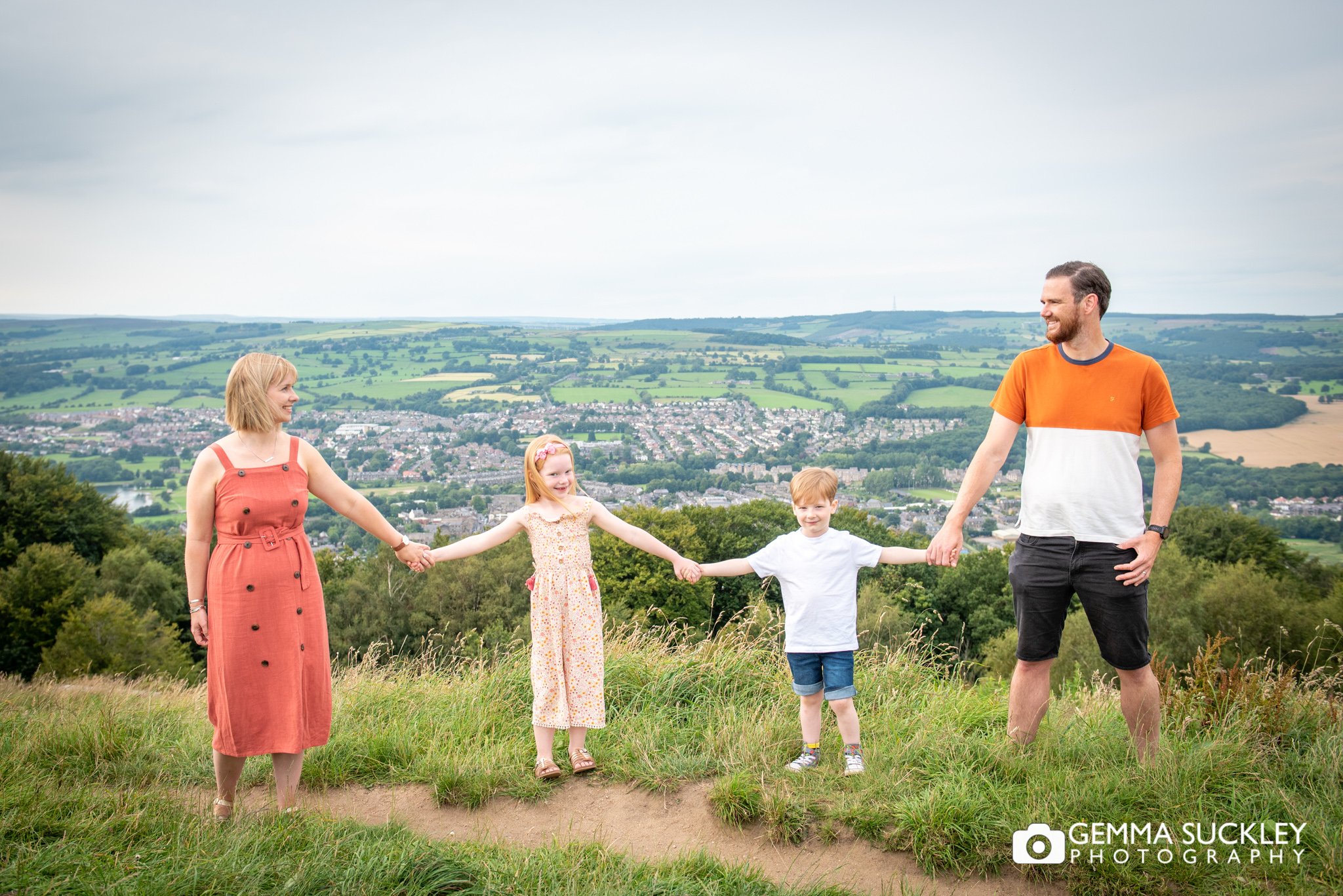 a family holding hands at surprise view on otley chevin
