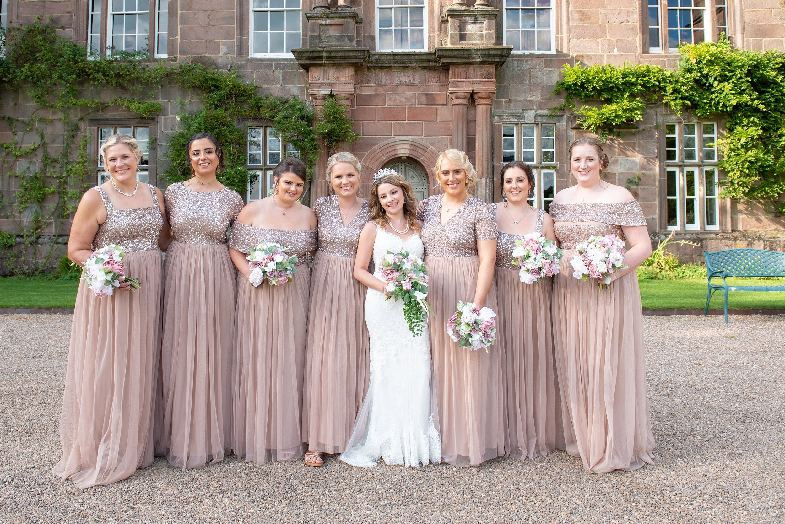 a wedding photo of the bride and her bridesmaids outside browsholme hall in clitheroe