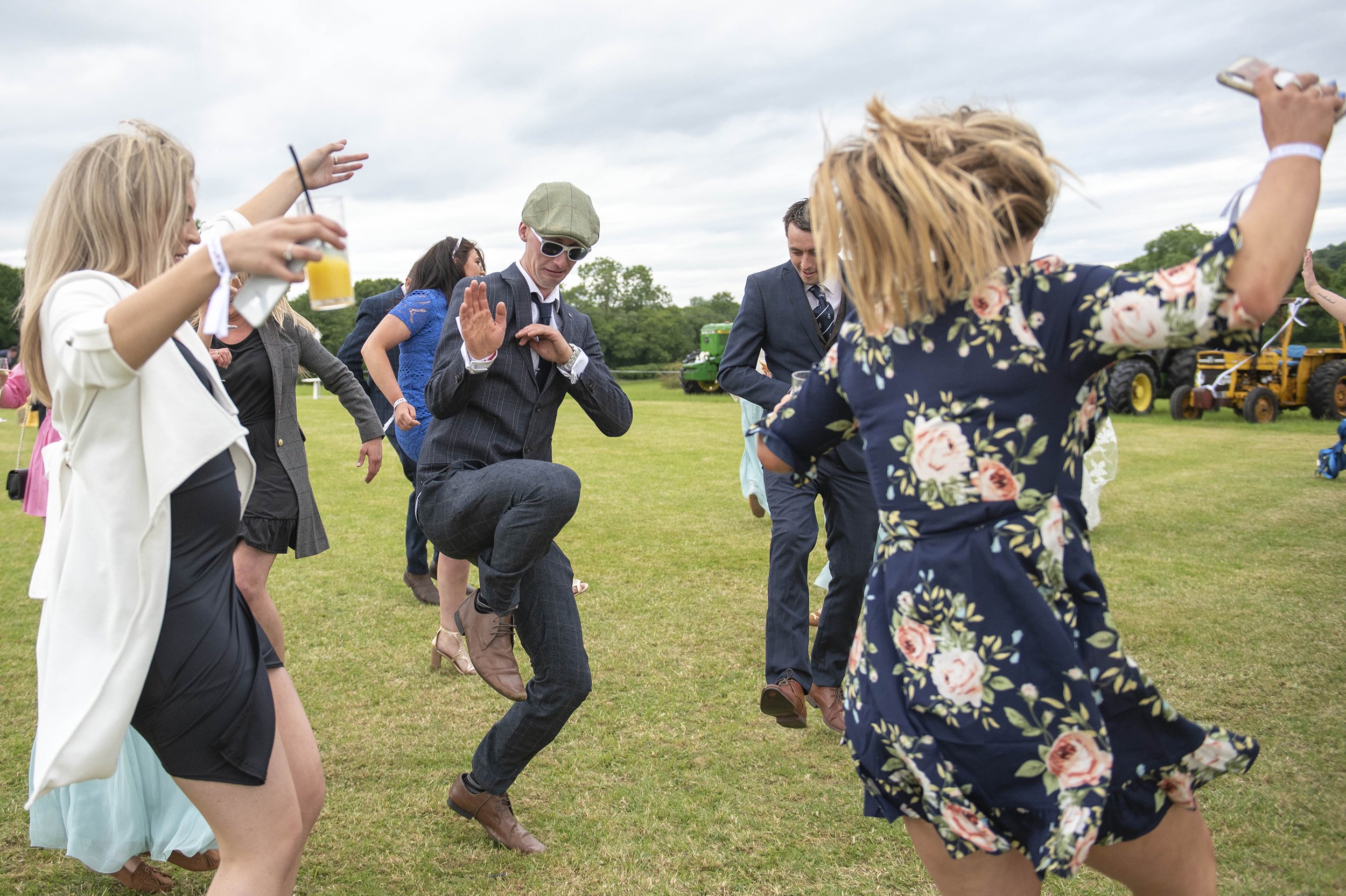 a group of wedding guests dancing at an outdoor wedding in clitheroe