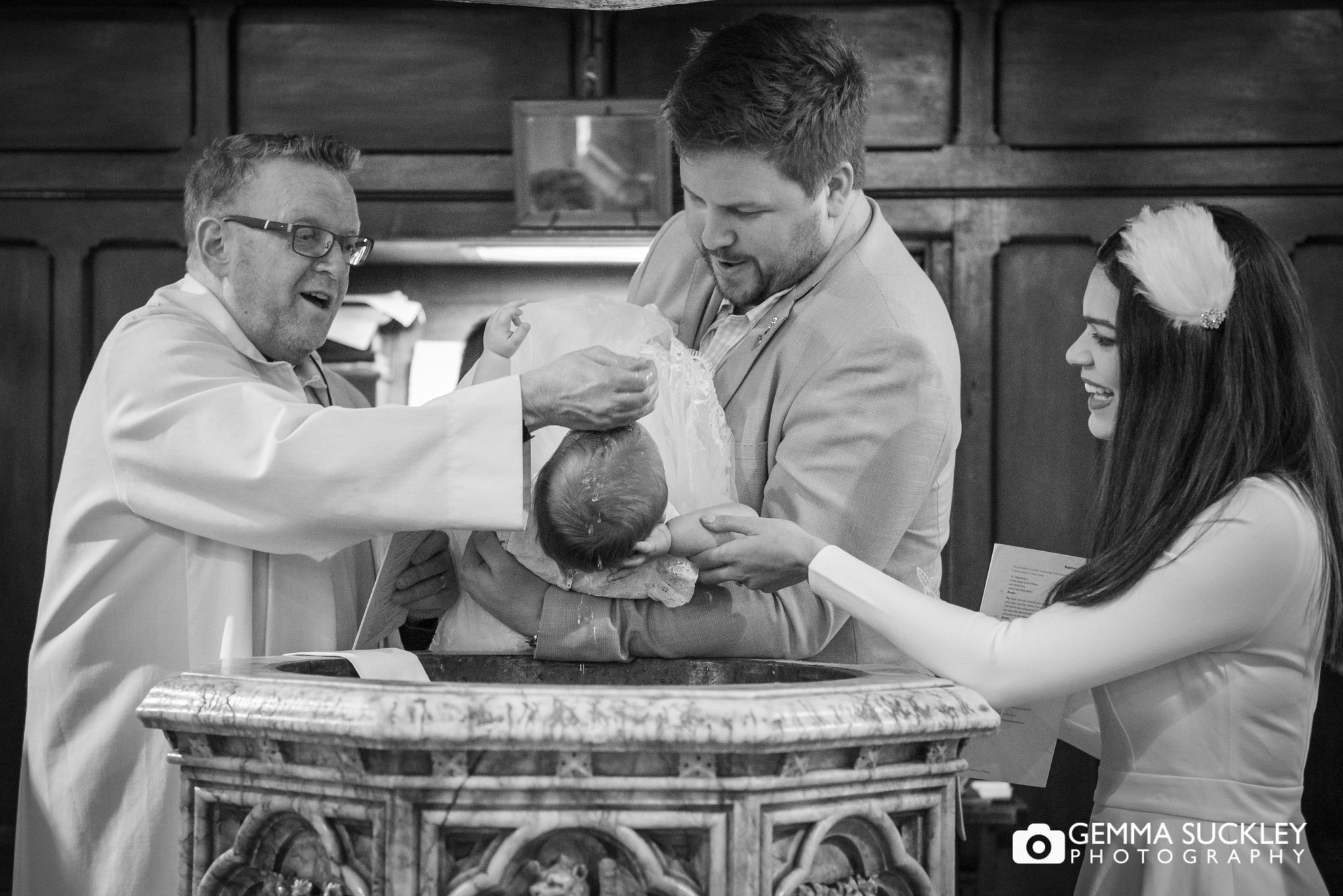 a vicar wets the babt's head at a christening in Gargrave 