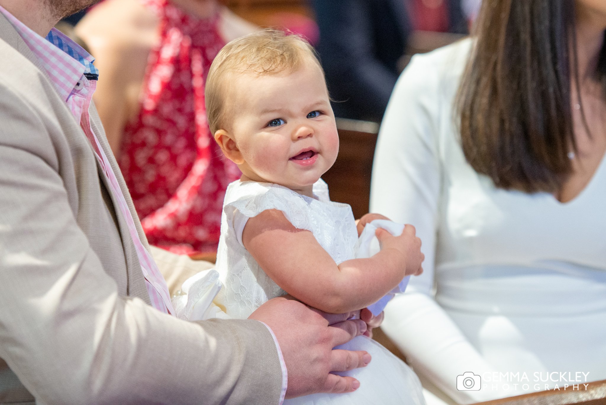 a close up photo of a baby in her christening dress