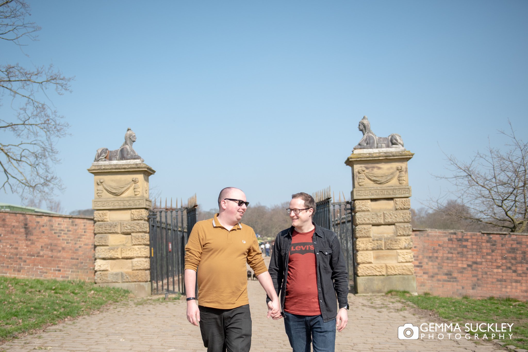 a couple walking through the gates at temple newsman for their engagement photo shoot