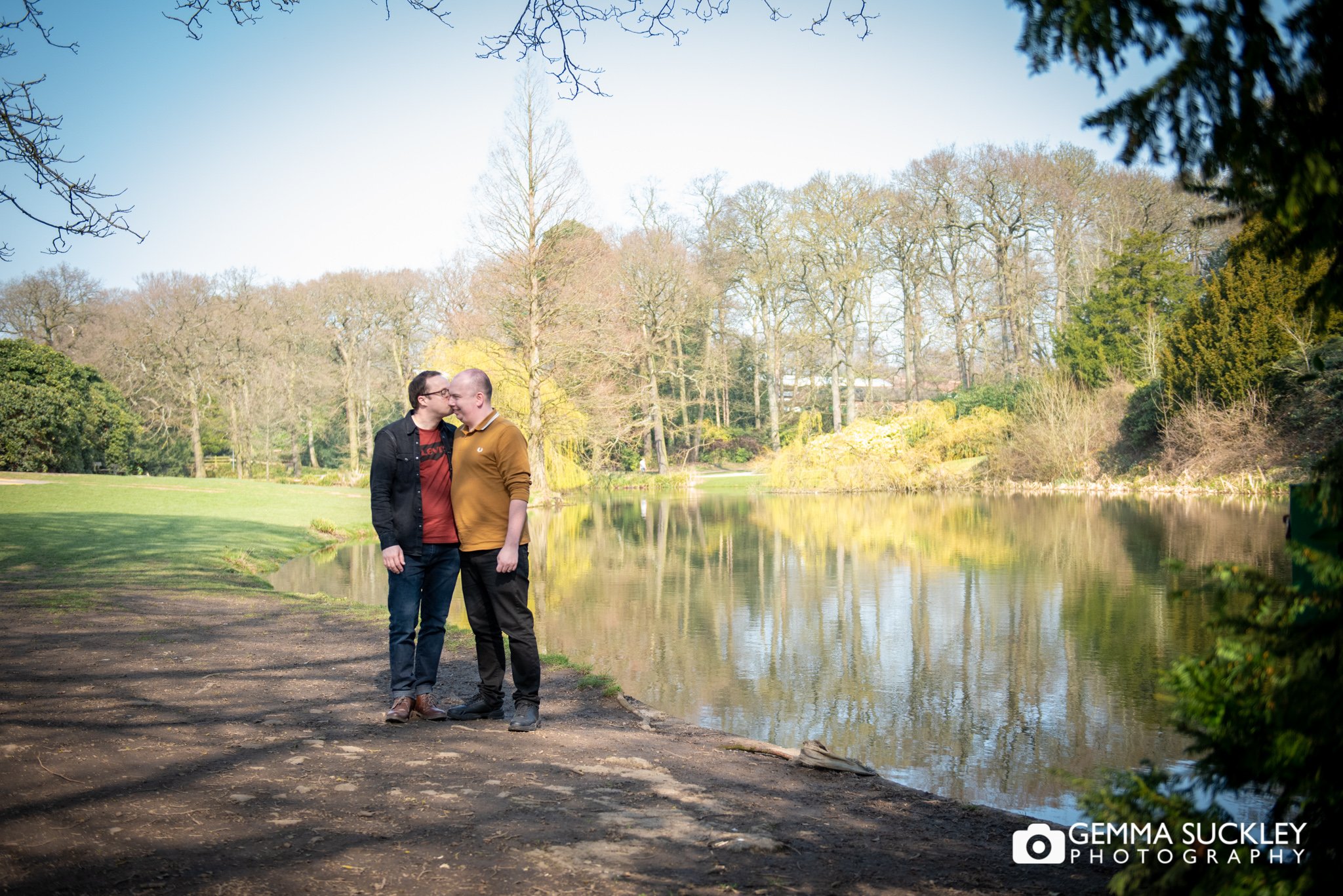 a hugging engaged couple by the pond at temple newsam