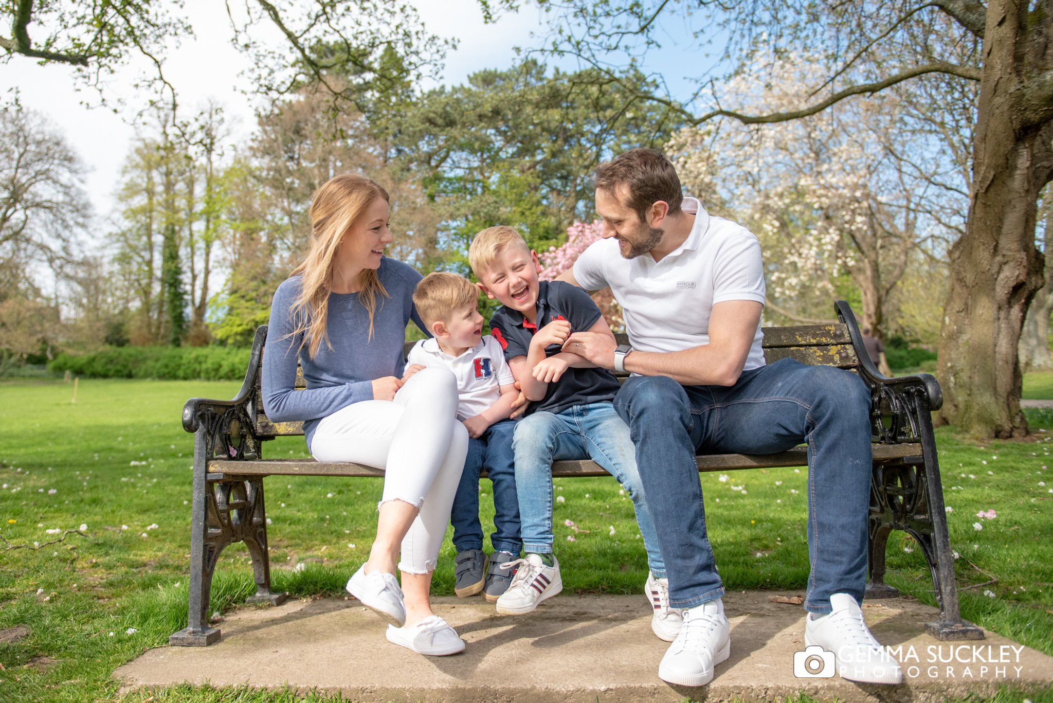parents sitting on a bench in skipton park with their children