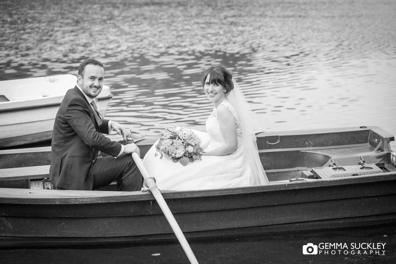 bride and groom in the row boat at coniston lake in skipton